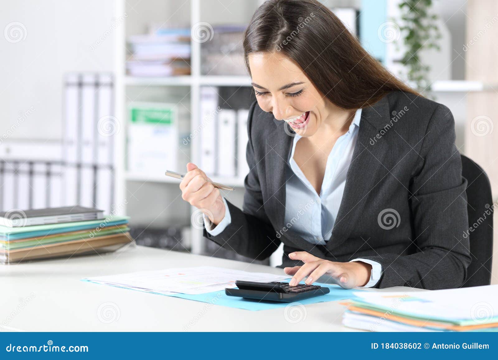 excited bookkeeper checking calculator at office