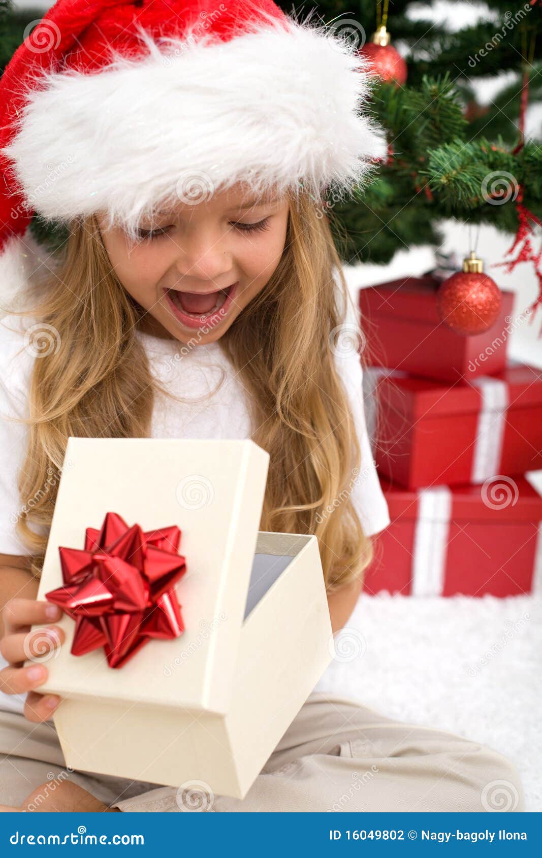 excited little girl opening christmas present