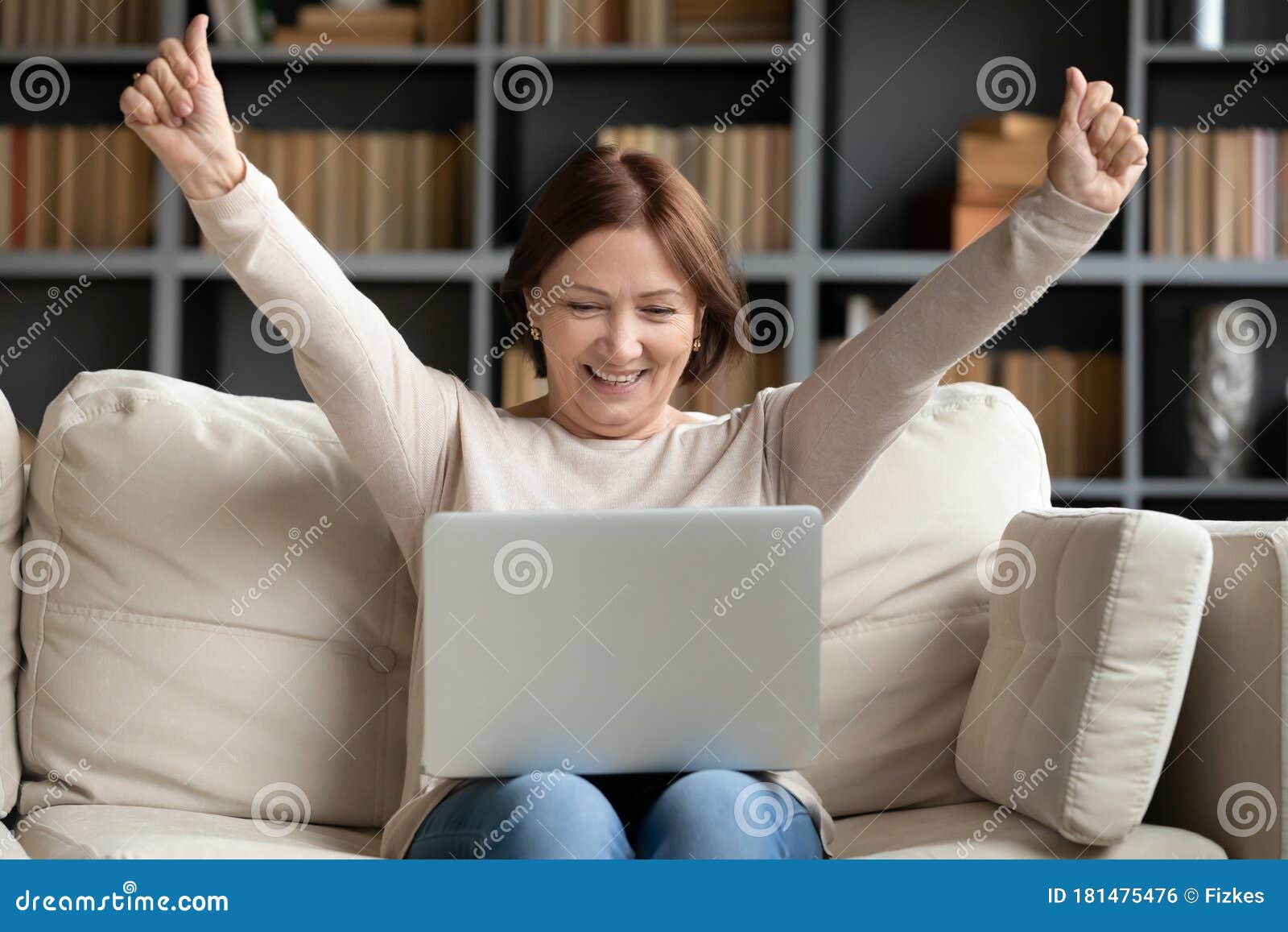 excited mature woman looking at laptop screen, reading good news