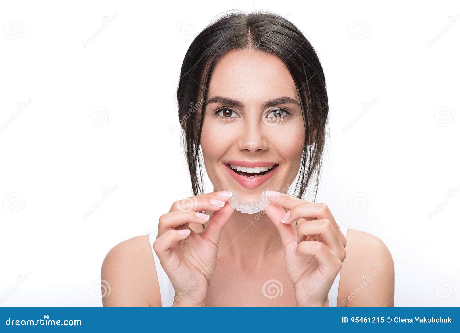 excited young woman holding clear aligner