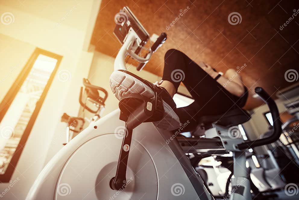 Exercise Bike Cardio Workout at Fitness Gym. Women Doing Sport Biking