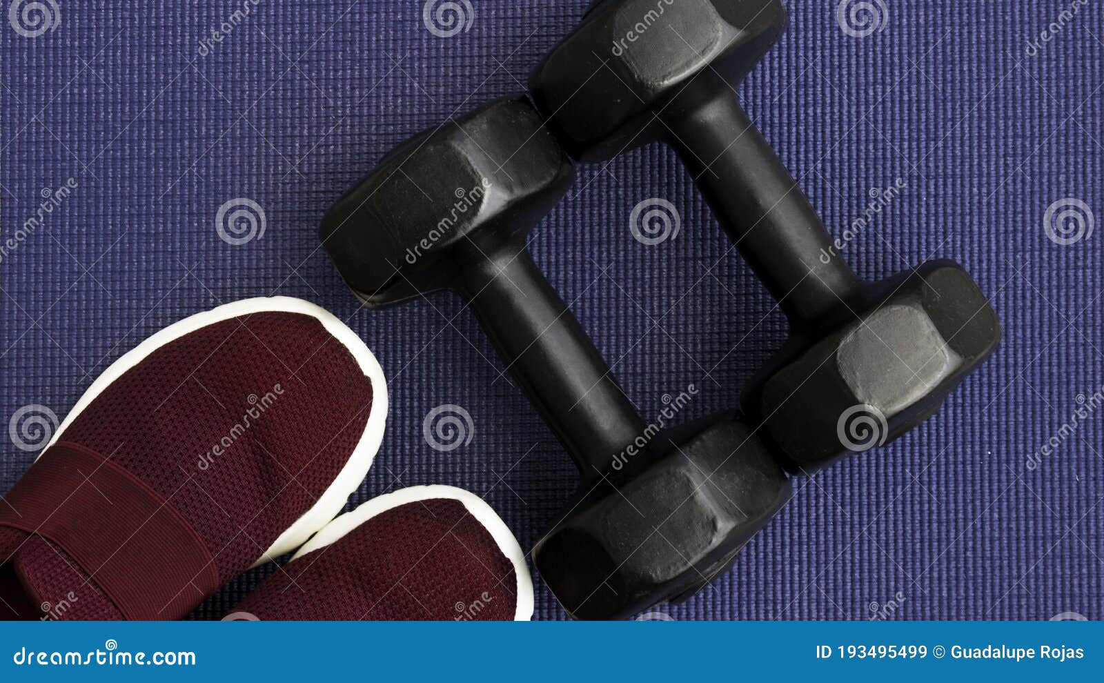 dumbbells and red tennis shoes on a yoga mat, exercise concept