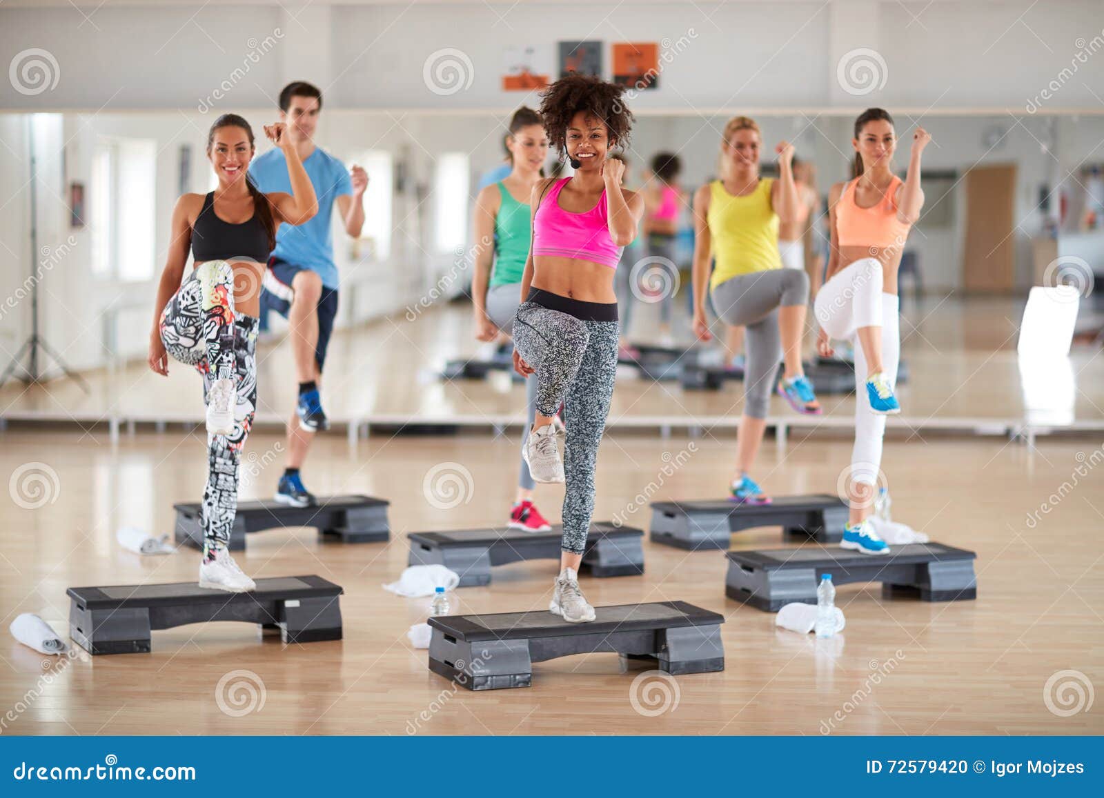 exercisers with female instructor on group training