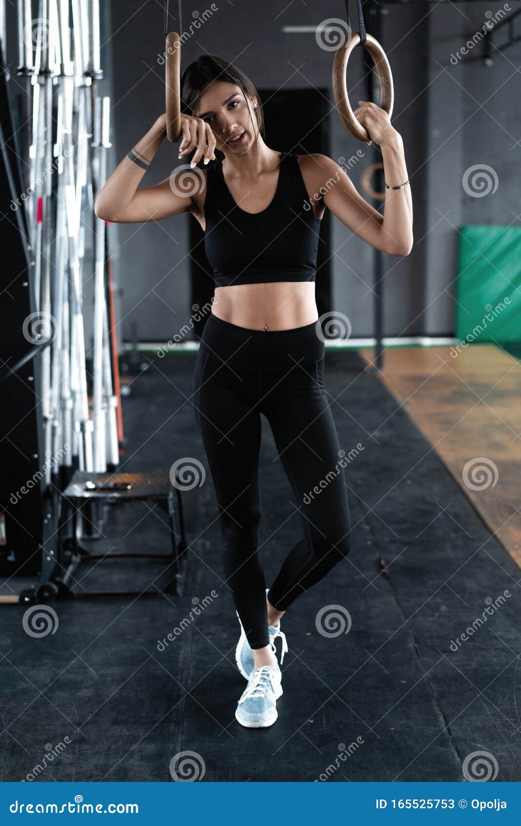 Working out Young athletic sportswoman exercising on gymnastic
