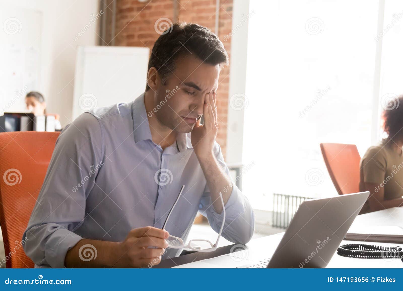 exhausted employee suffer from dizziness working at laptop