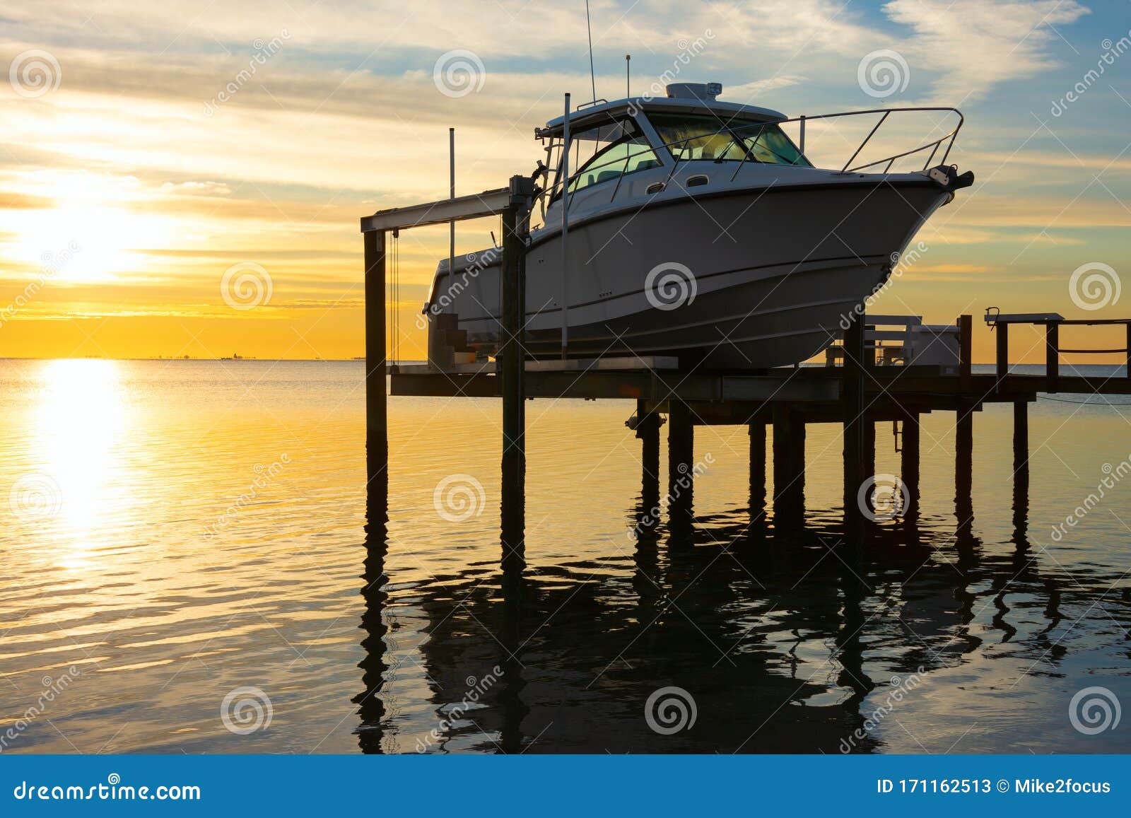 expensive fishing boat on motorized electric dock vessel lift at sunrise
