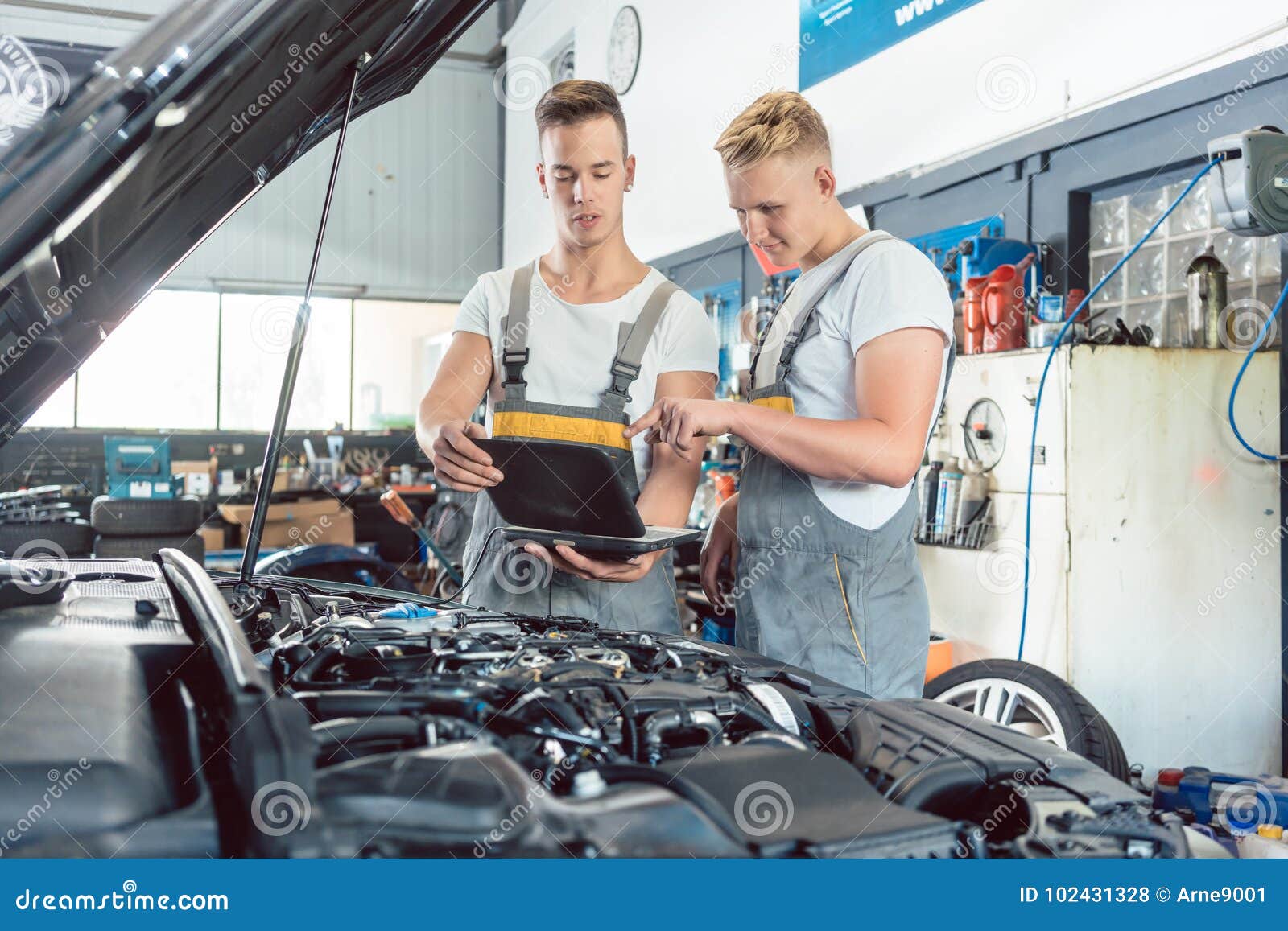 experienced auto mechanic using a laptop for scanning engine err