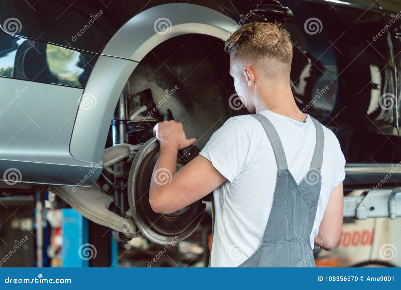 experienced mechanic replacing the disk brakes of a car in a mod