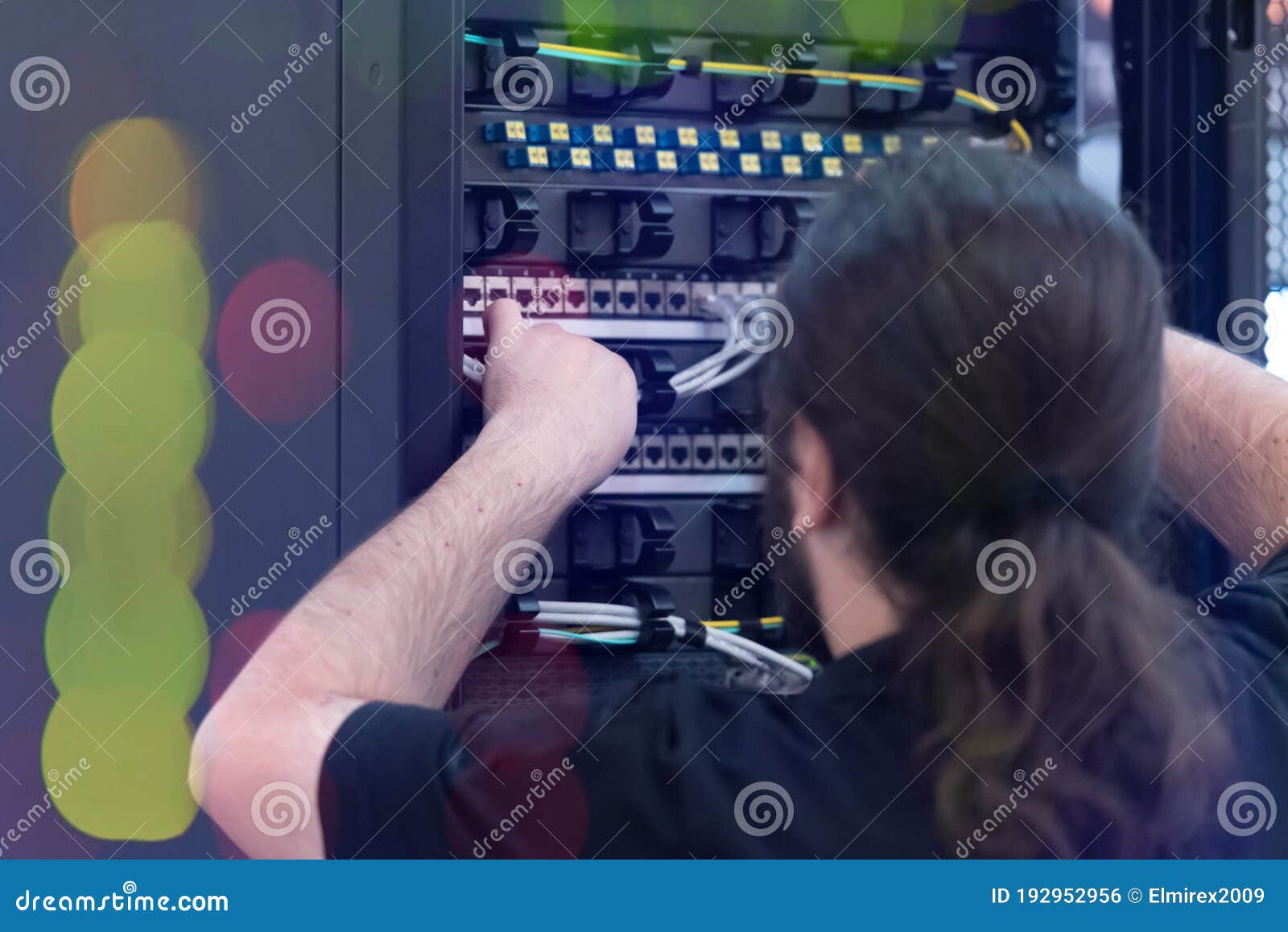 An Expert Engeneer in Datacenter Server Room Connecting Cables in
