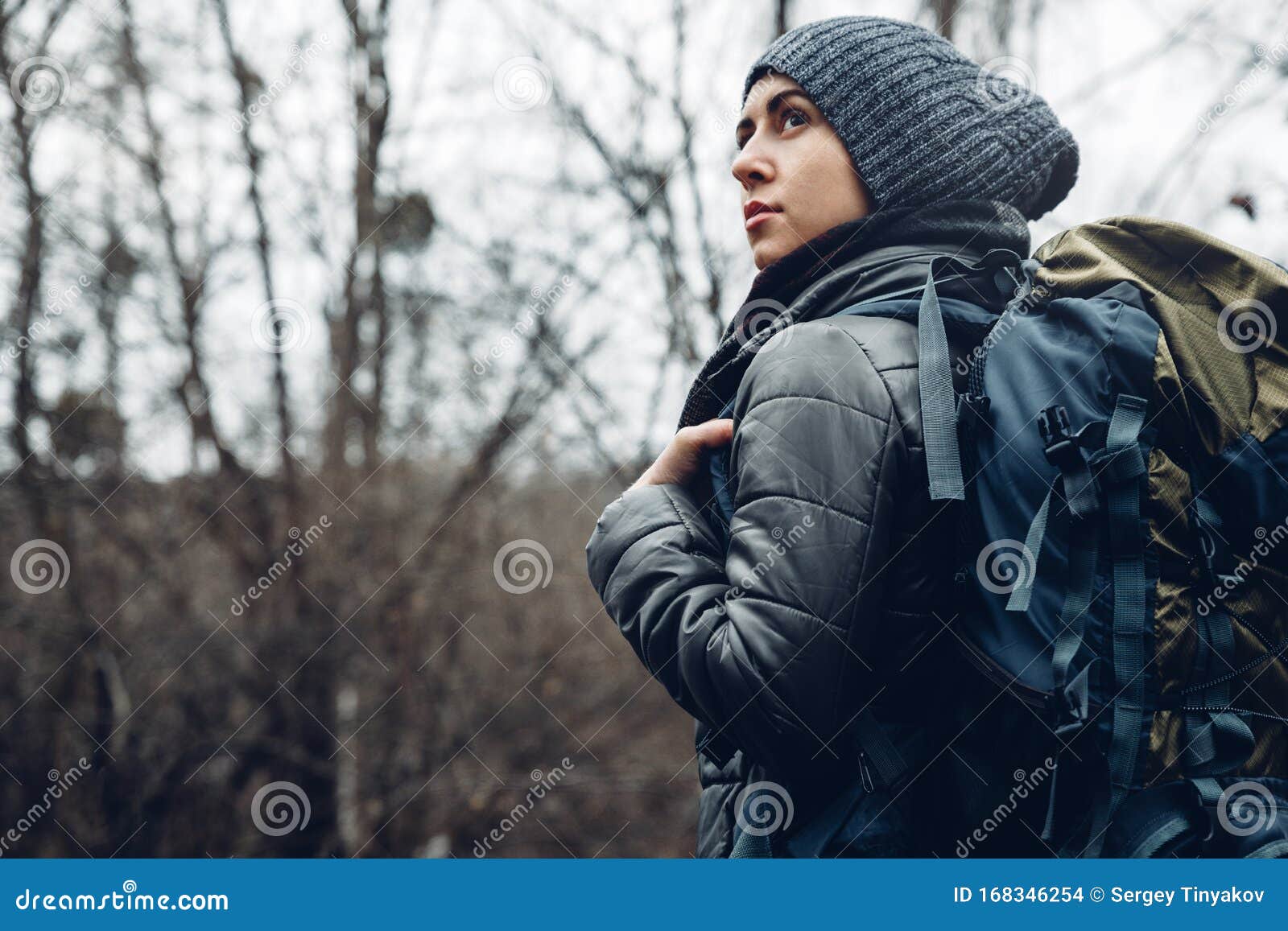 explorer young woman with backpack walking in forest, rear view. adventure bushcraft survival scouting