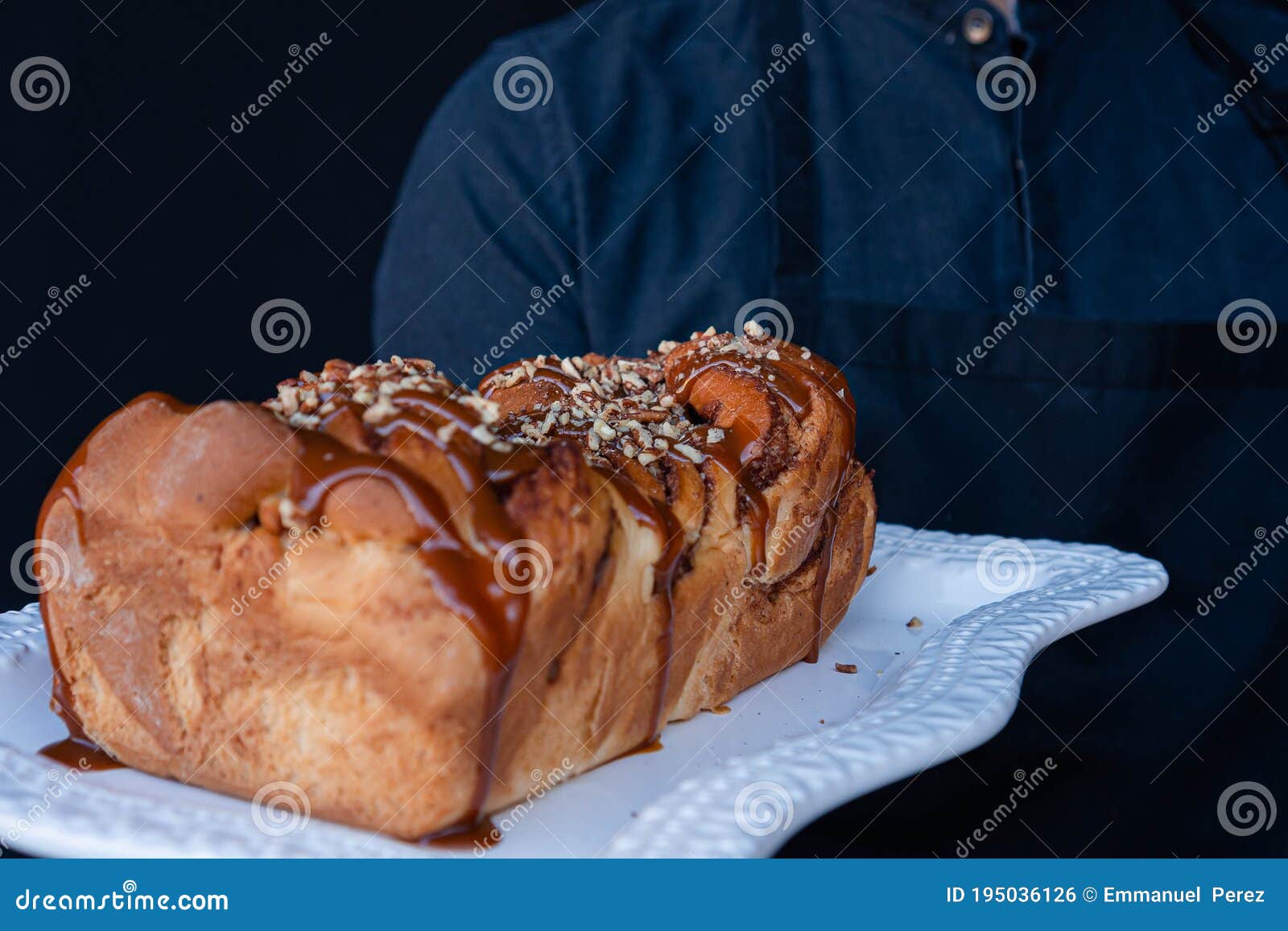 exquisite freshly baked trenza bread decorated with caramel and walnuts on a white plate