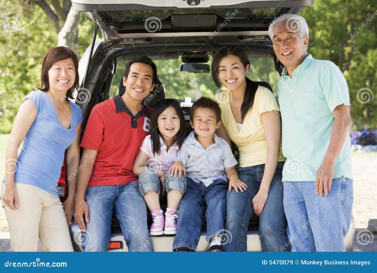 extended family sitting in tailgate of car