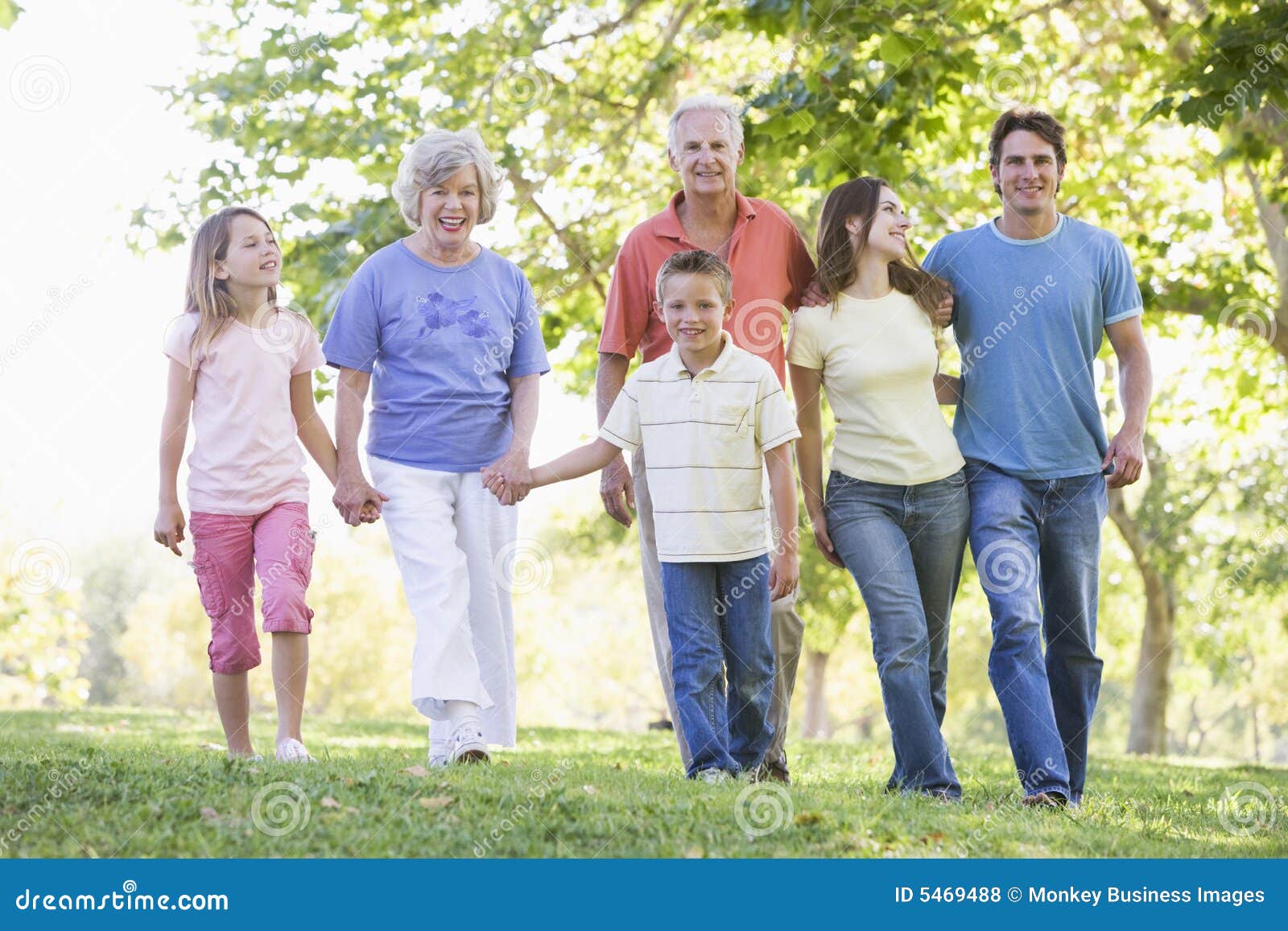 extended family walking in park holding hands