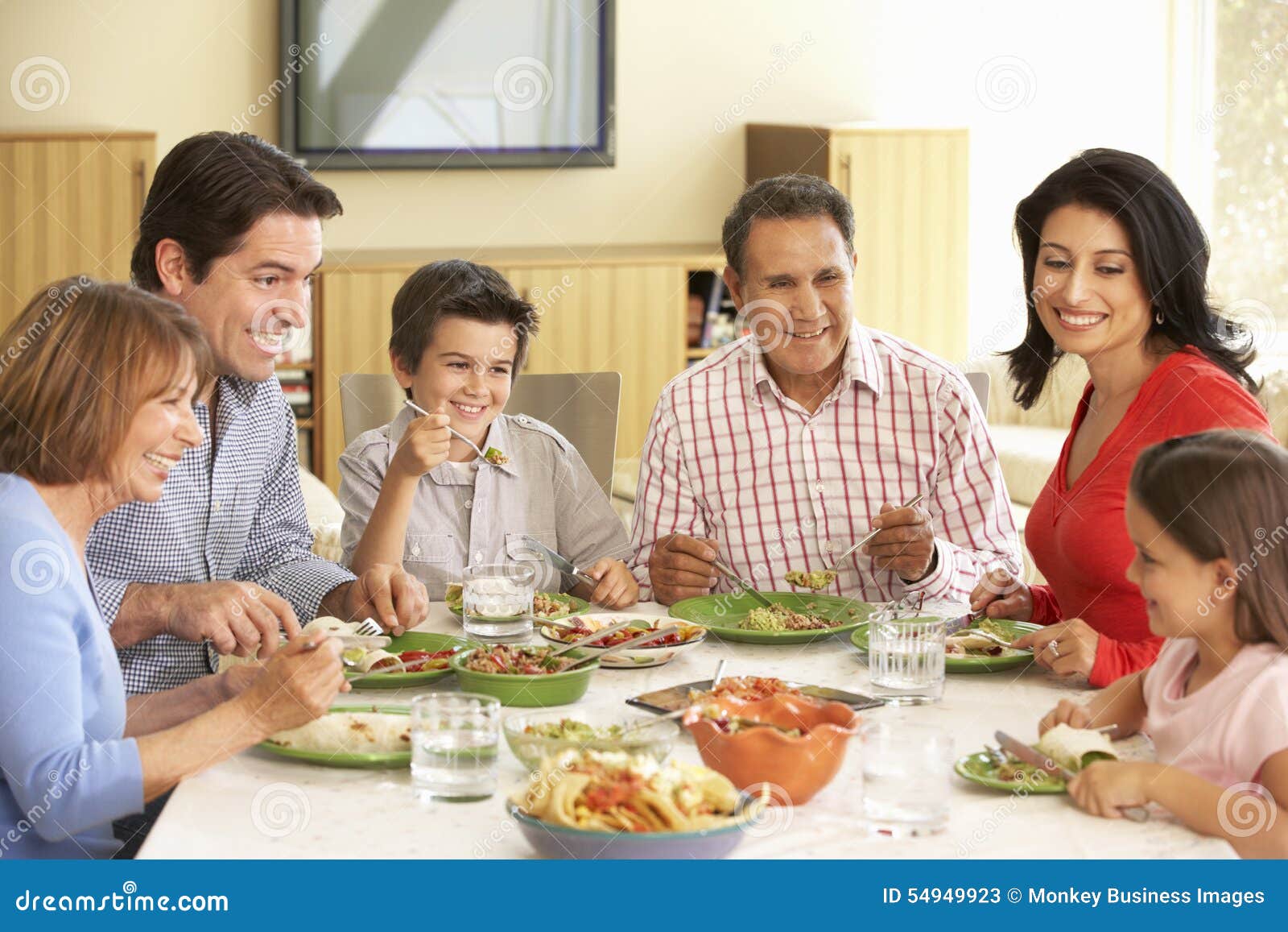 extended hispanic family enjoying meal at home