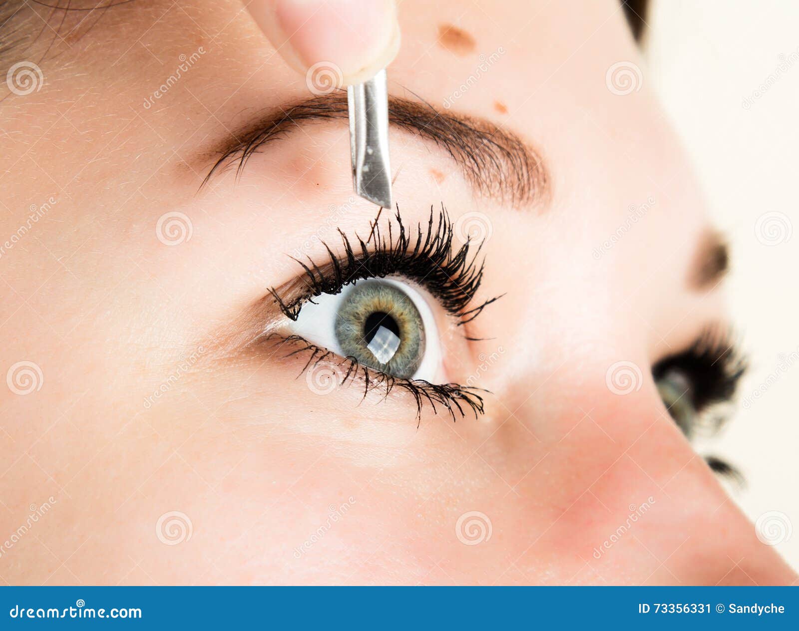 mulher de beleza aplicando máscara sob os olhos olhando-se no