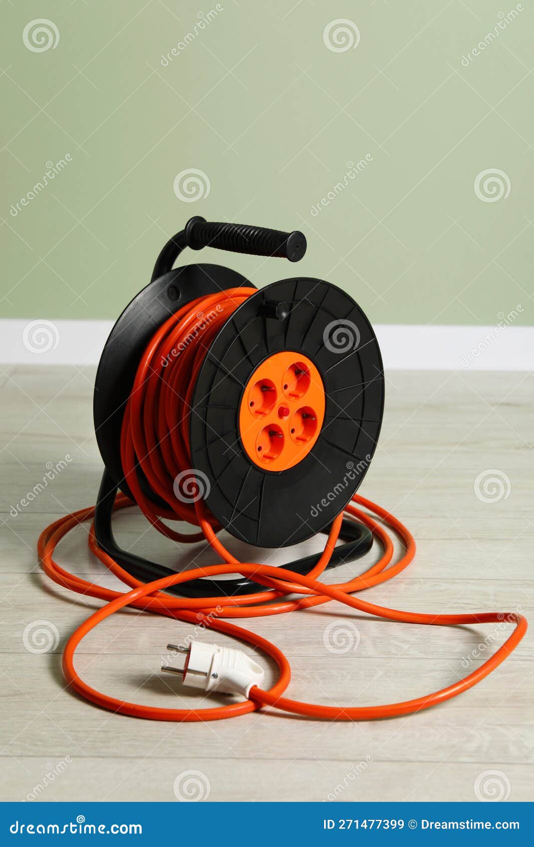 Extension Cord Reel on Floor Near Light Green Wall. Electrician S