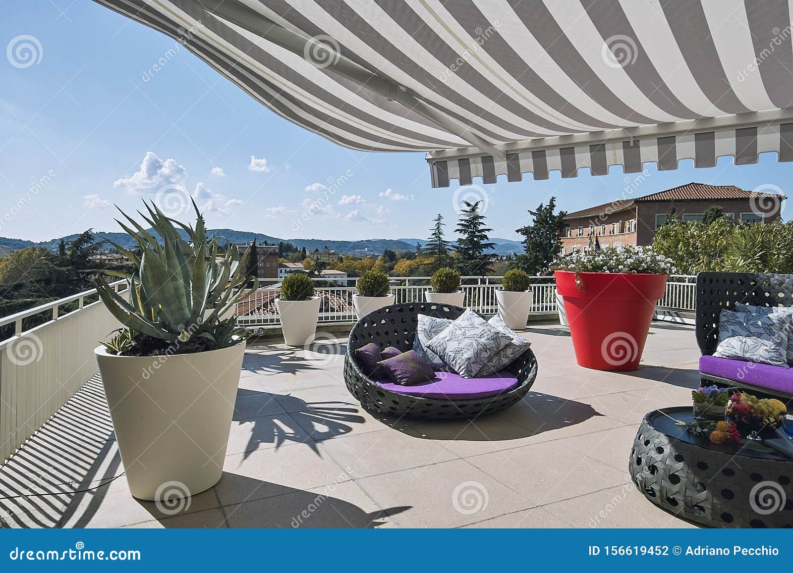 exteriors shots of a modern terrace with awnings and sofas