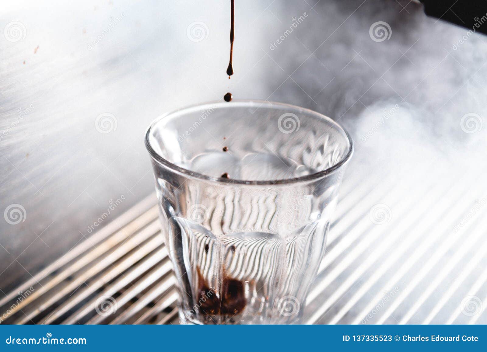 Extractie van een espresso met helder licht. Vochtige koffieextractie van espressomachine met helder licht en koffieglas