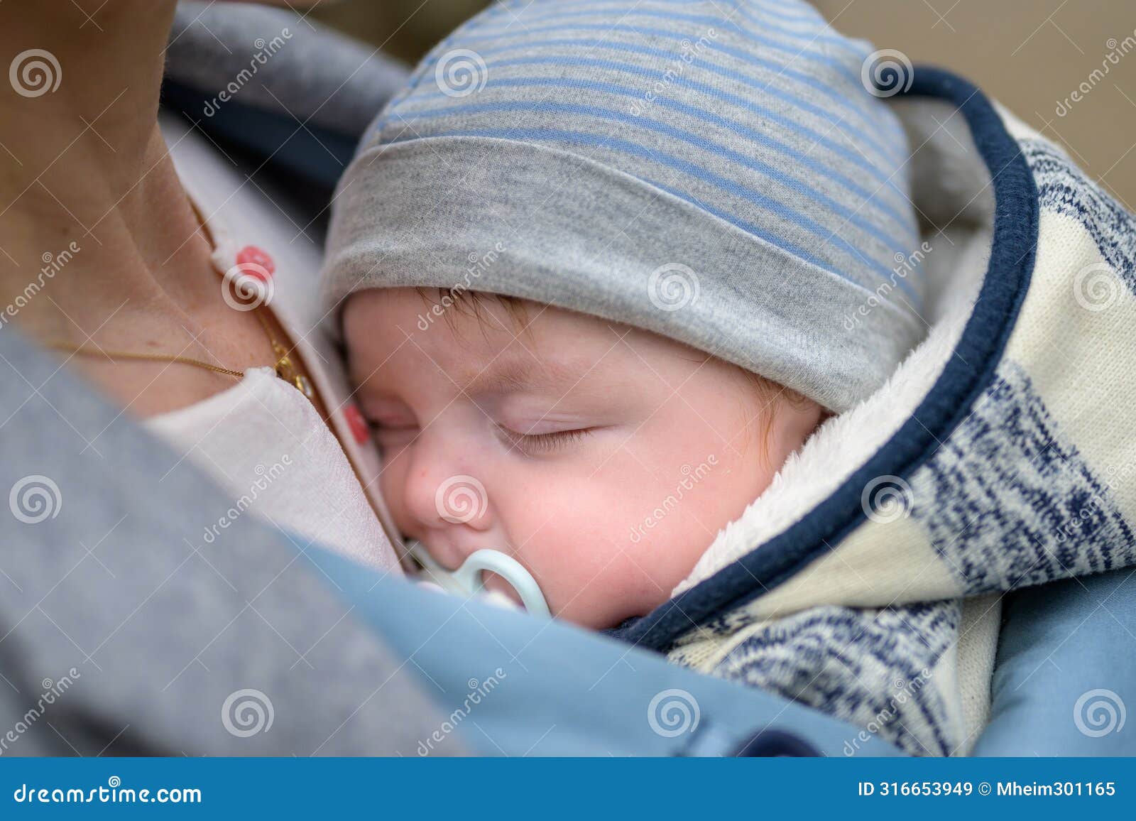 extreme close up of a baby sleeping in a baby carrier, in an extraordinary closeness to his mother