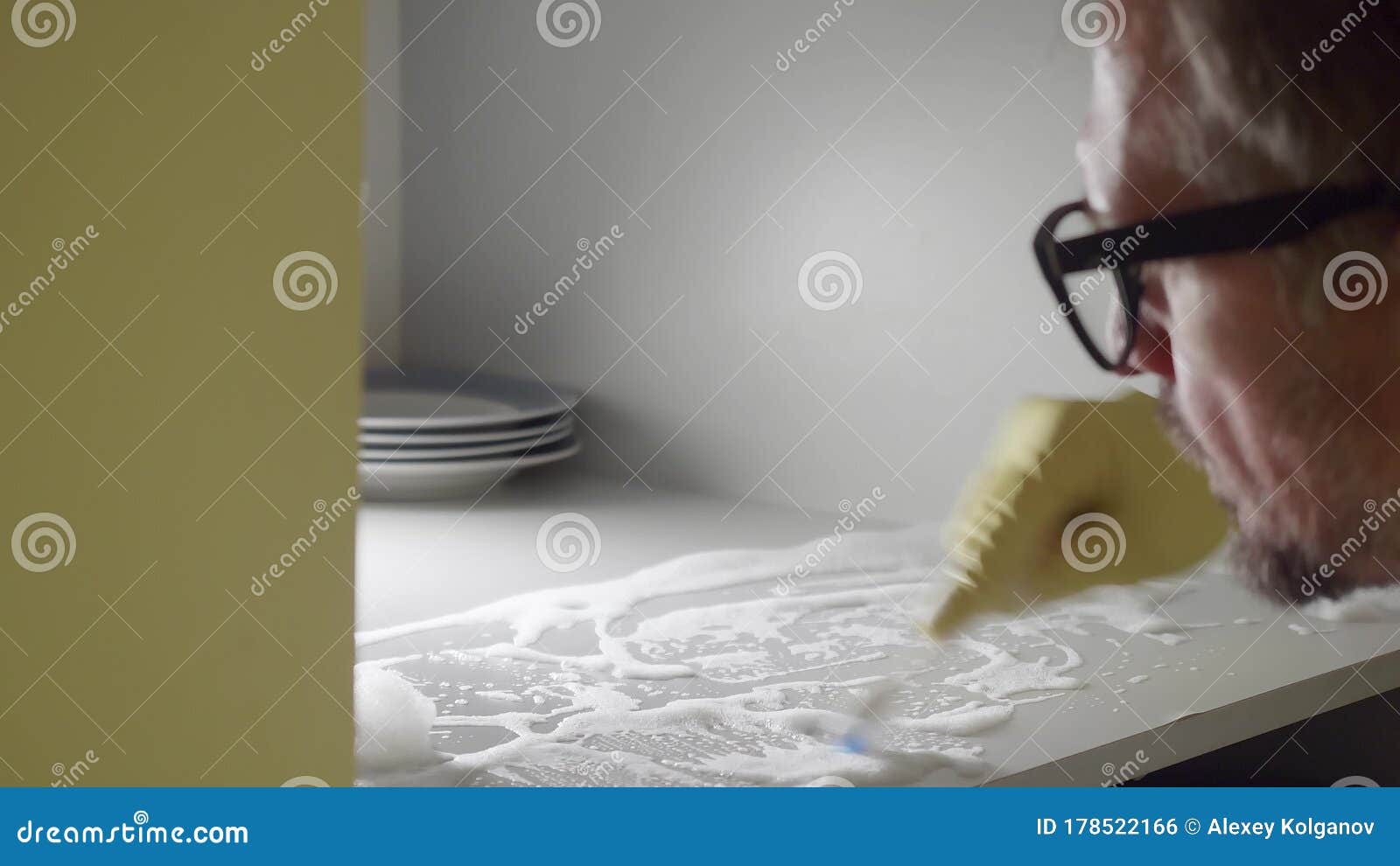 Eye Angle and Side View of Man Cleaning White Soapy Shelf of Cupboard