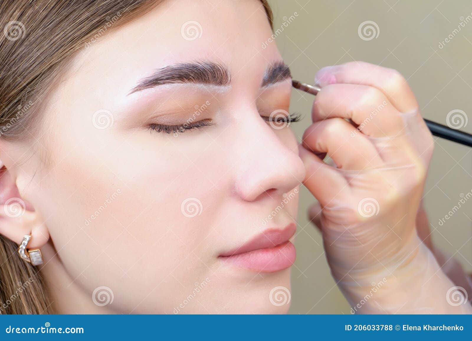 eyebrow coloring. woman applying brow tint with makeup brush closeup