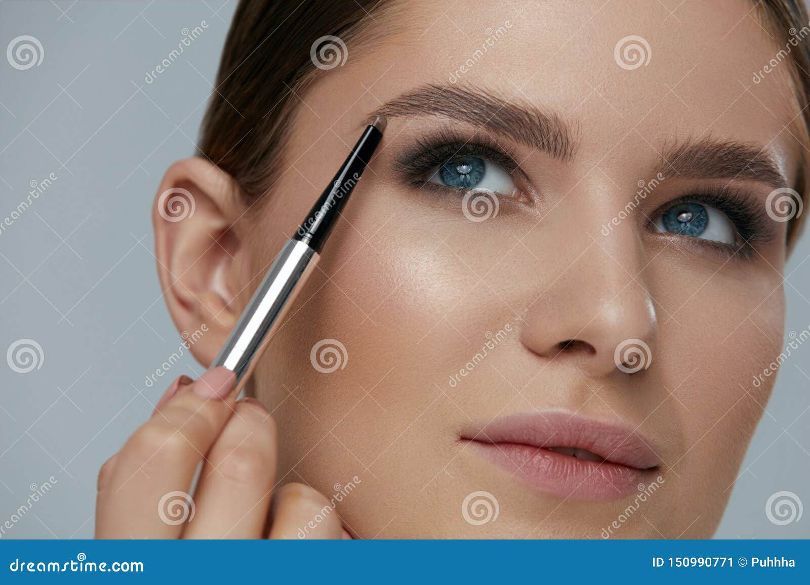 eyebrow makeup. beauty model shaping brows with brow pencil