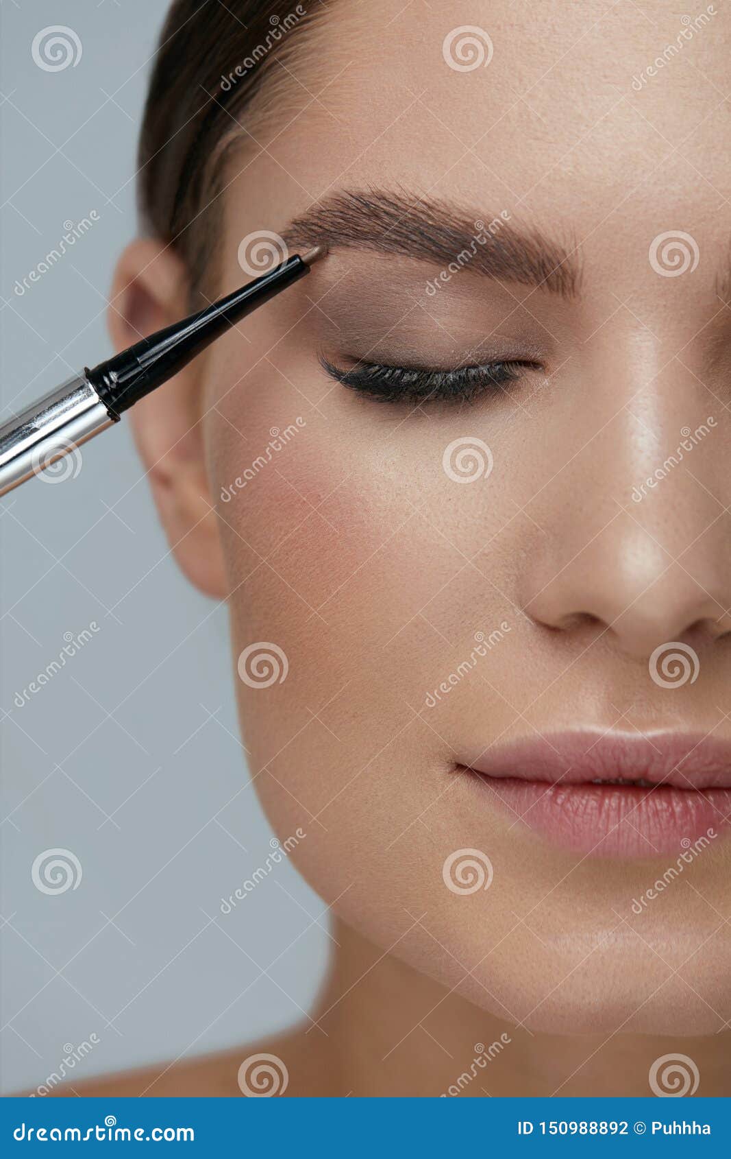 eyebrow makeup. beauty model shaping brows with brow pencil