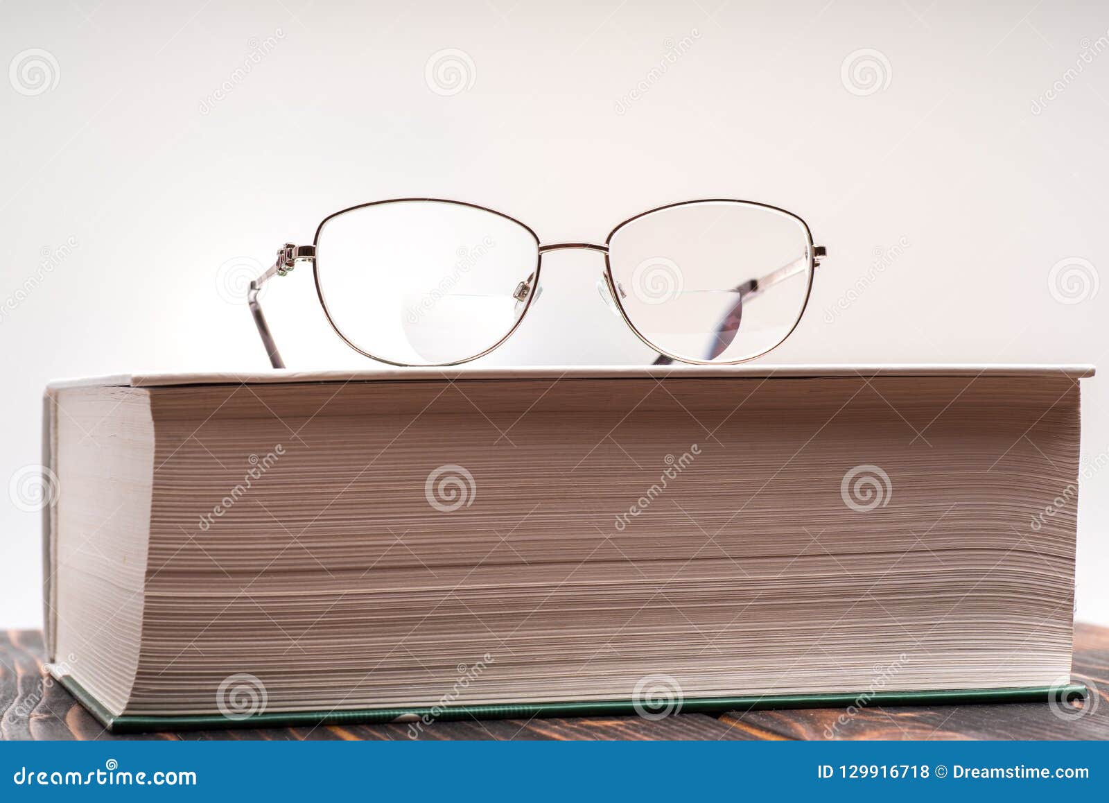 eyeglasses with bifocal lenses on book