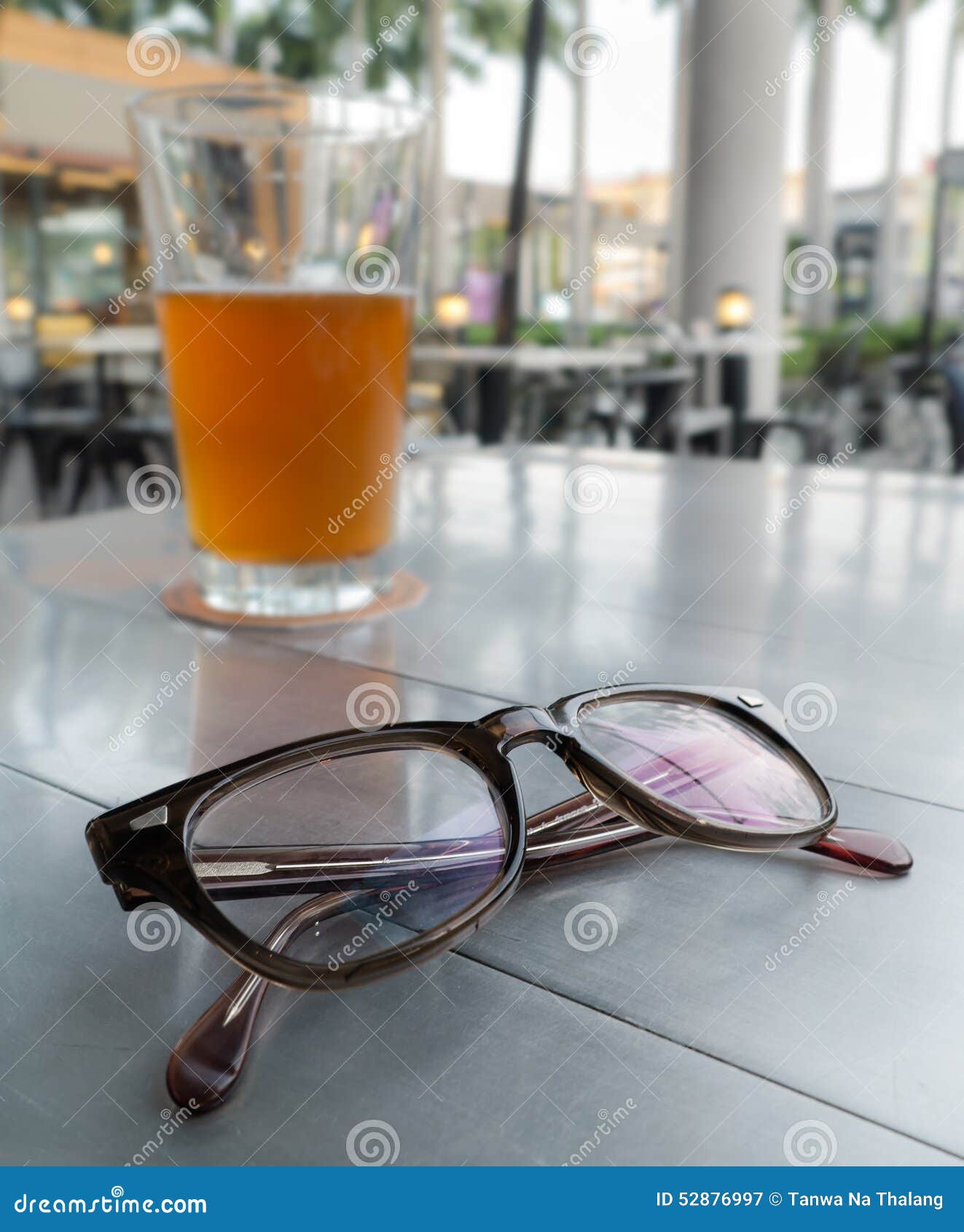 Eyeglasses on a Table and Background is Glass of Beer Stock Image