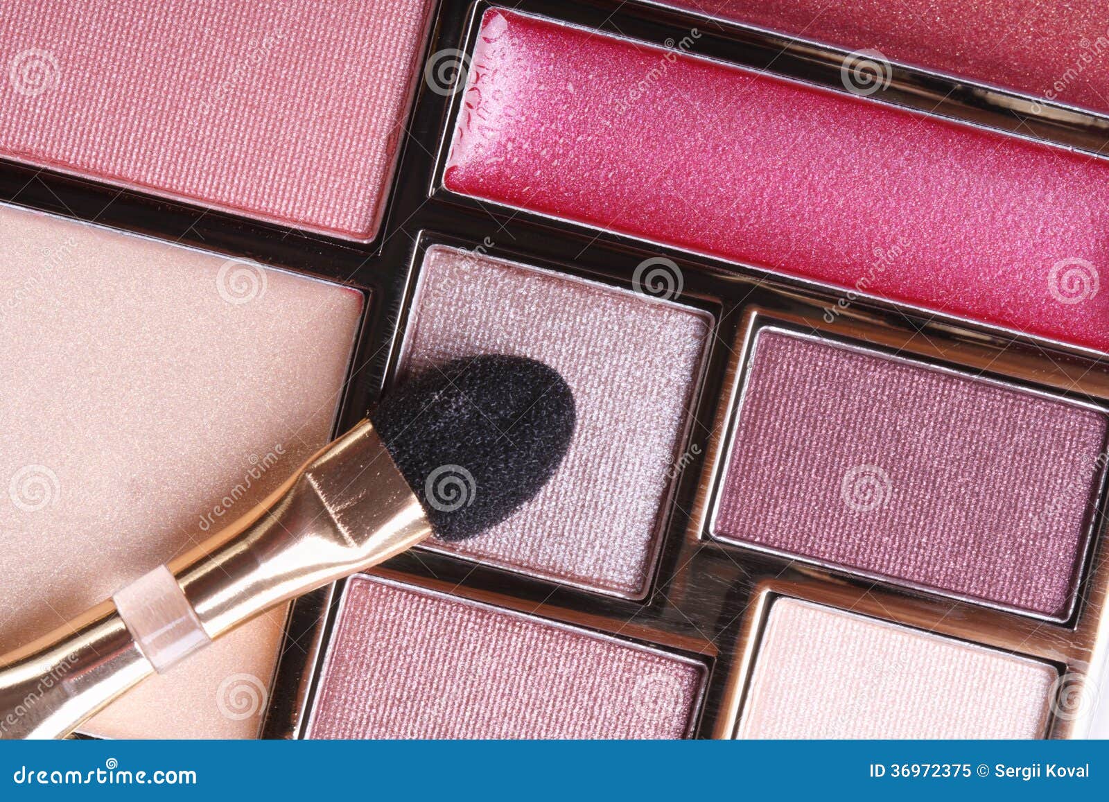 Eyeshadow in pink tones and lip gloss and applicator close-up. macro