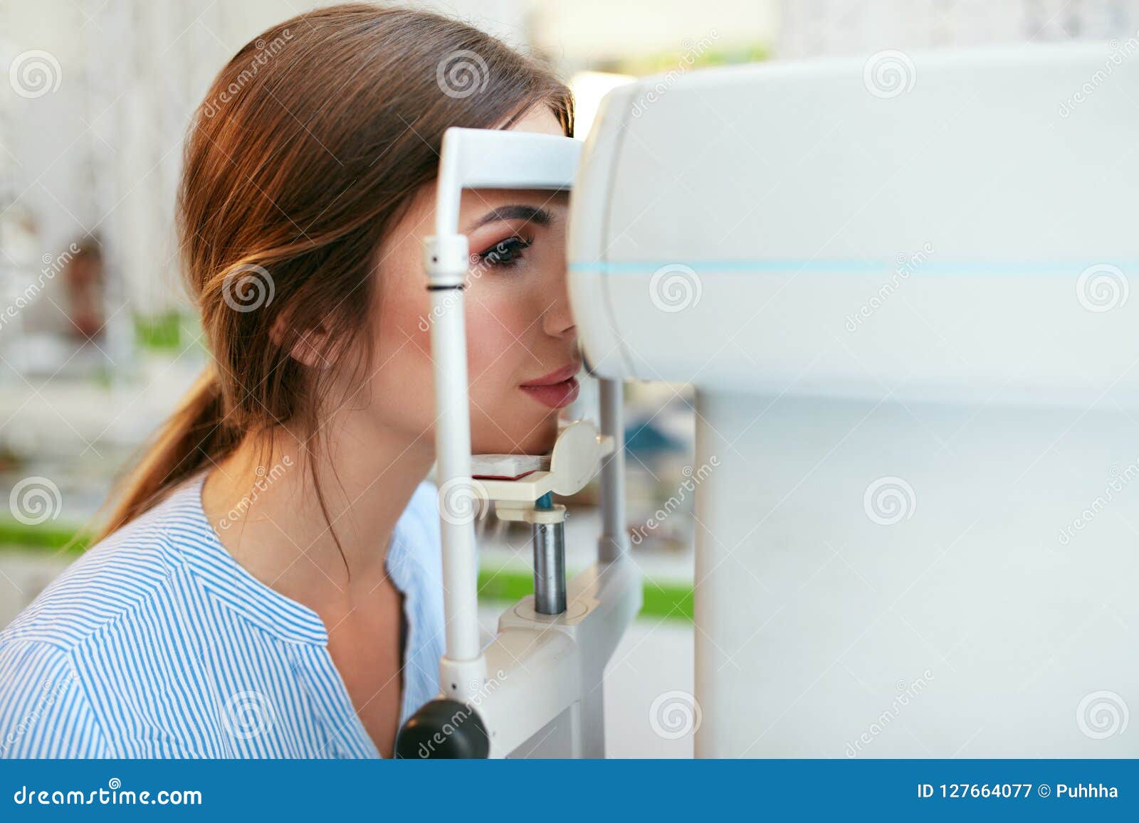 eyesight exam. woman checking eye vision on optometry equipment