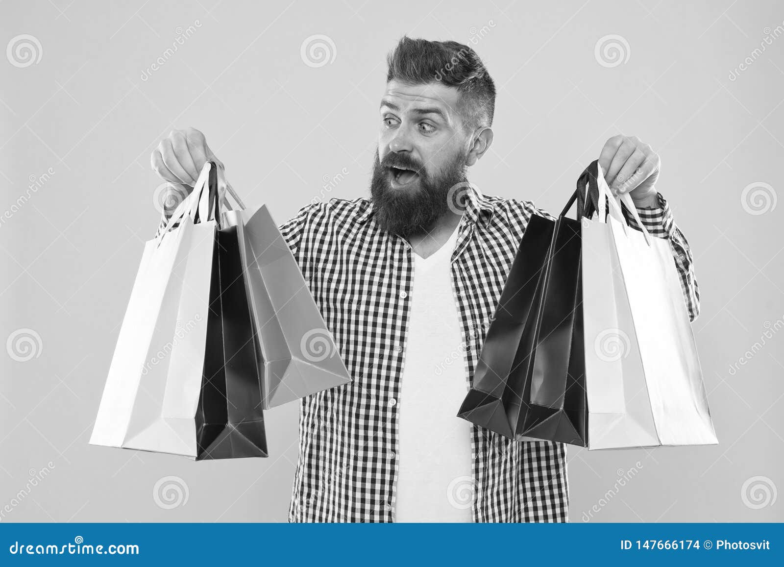 Make shopping more joyful. Enjoy shopping profitable deals black friday. Shopping with discount enjoy purchase. Man bearded hipster cheerful face carry paper shopping bags on yellow background.