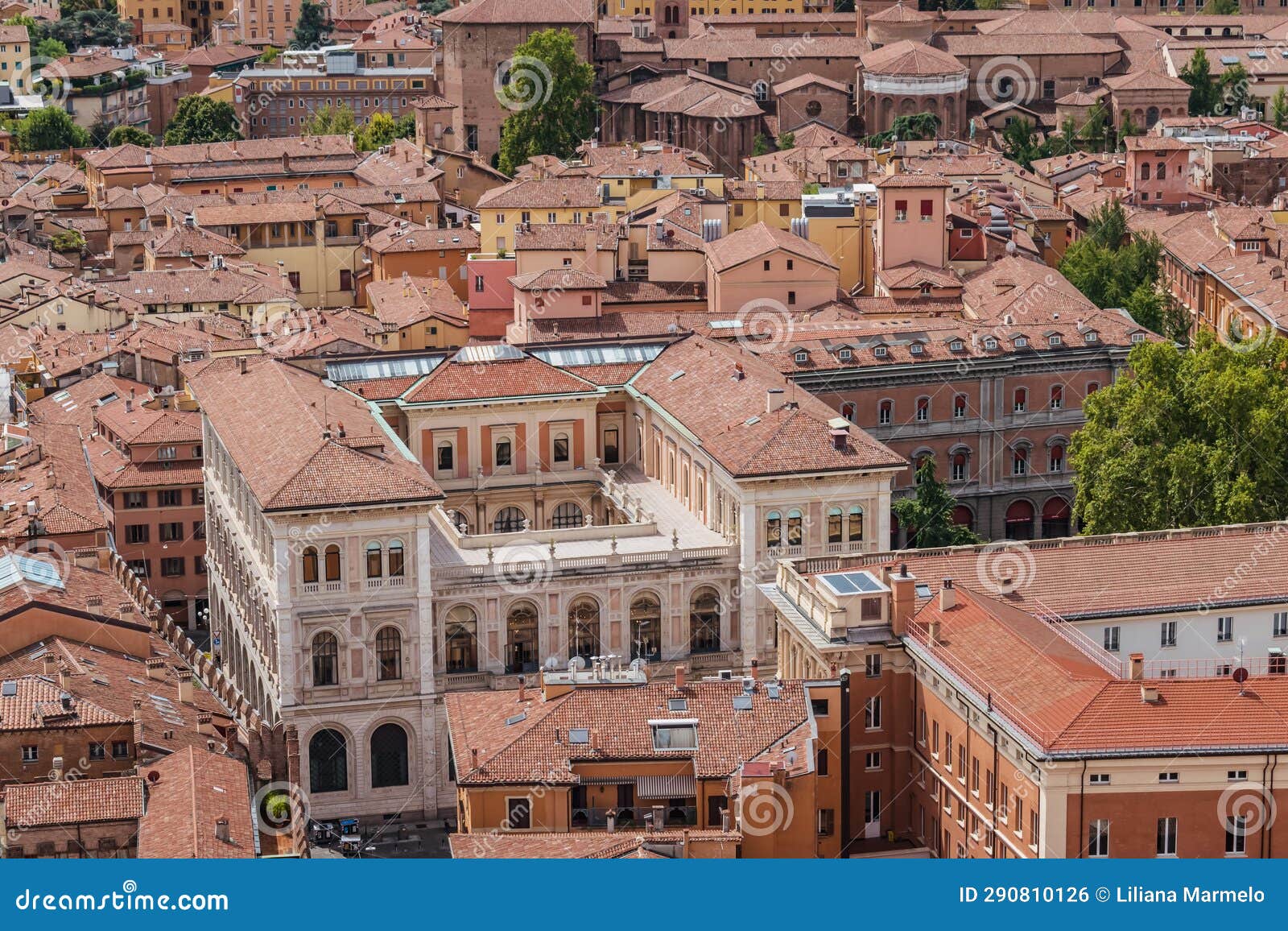 facade in aerial view of cassa di risparmio palace with basilica in background, bologna italy