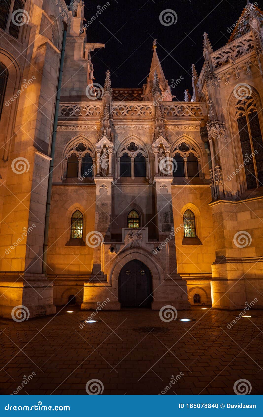 facade of matthias church at night with ligtht on budapest holy trinity square