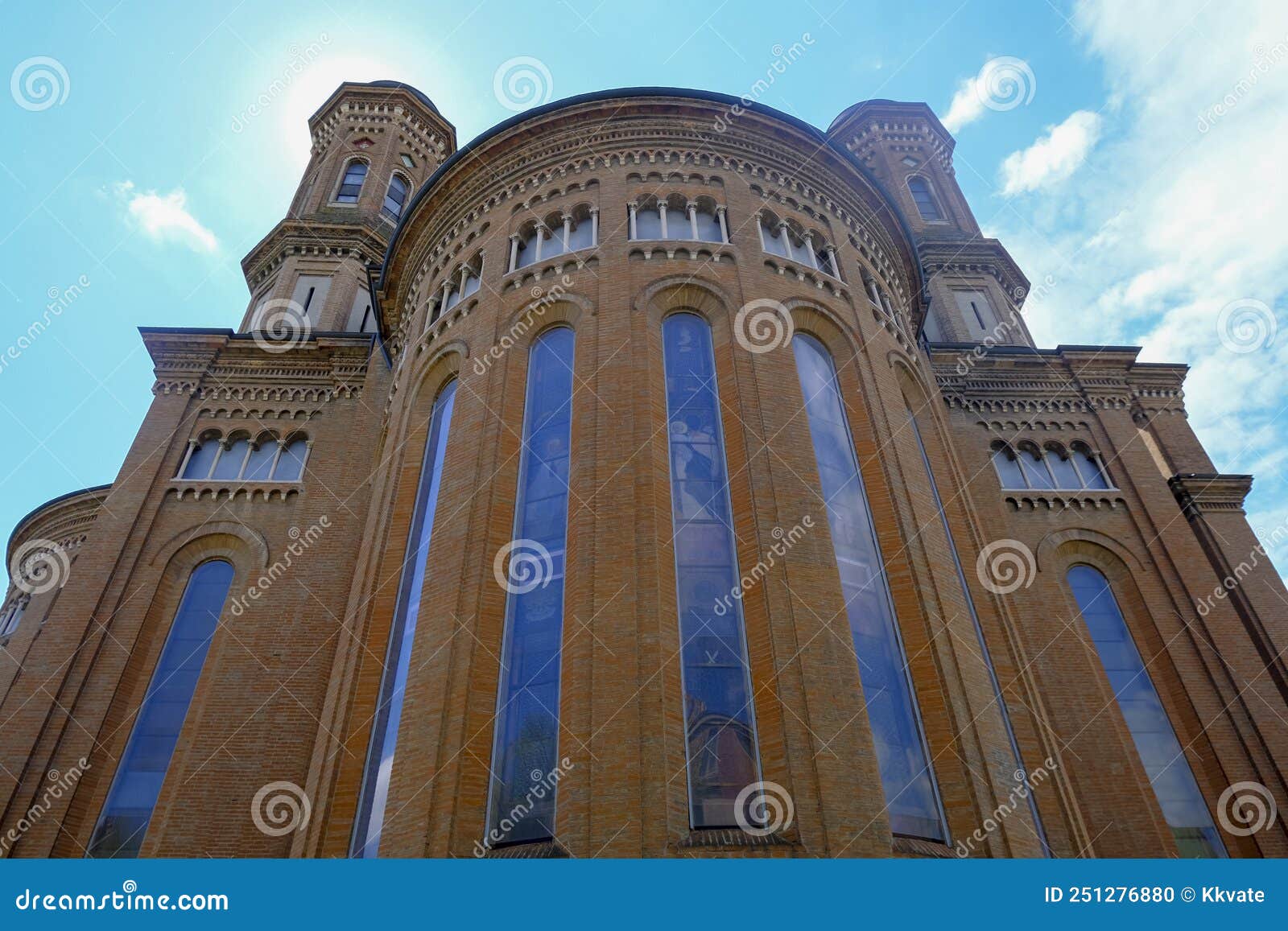 facade of monumental cathedral in modena, italy, tempio monumentale ai caduti di guerra across the blue sky from beneath