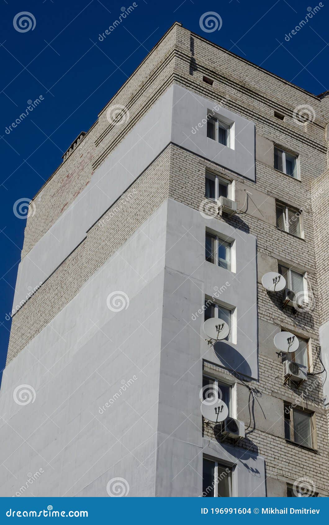 facade of a multi-storey building with many satellite antennas