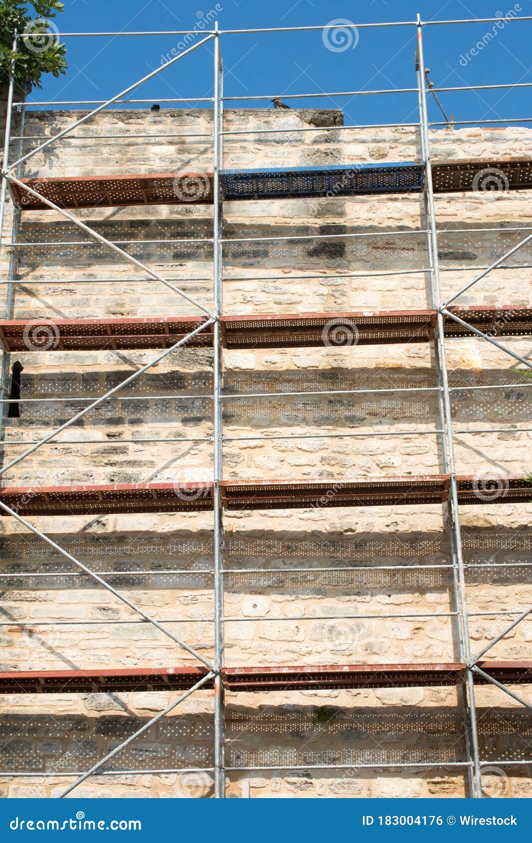 Facade of an Old Brick Wall with Scaffolding or H-frame Structure Stock