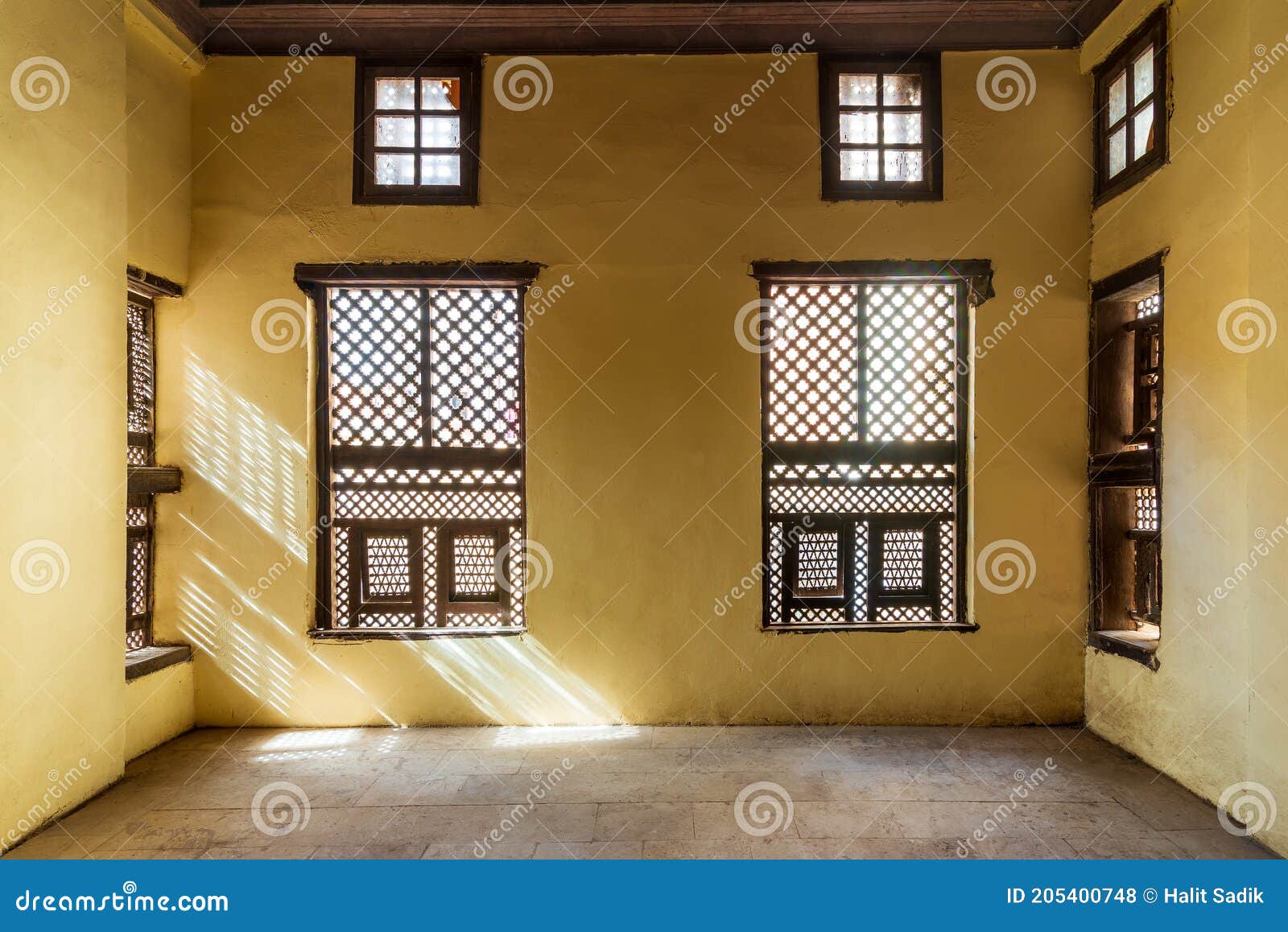 facade of two interleaved wooden ornate windows - mashrabiya - in stone wall