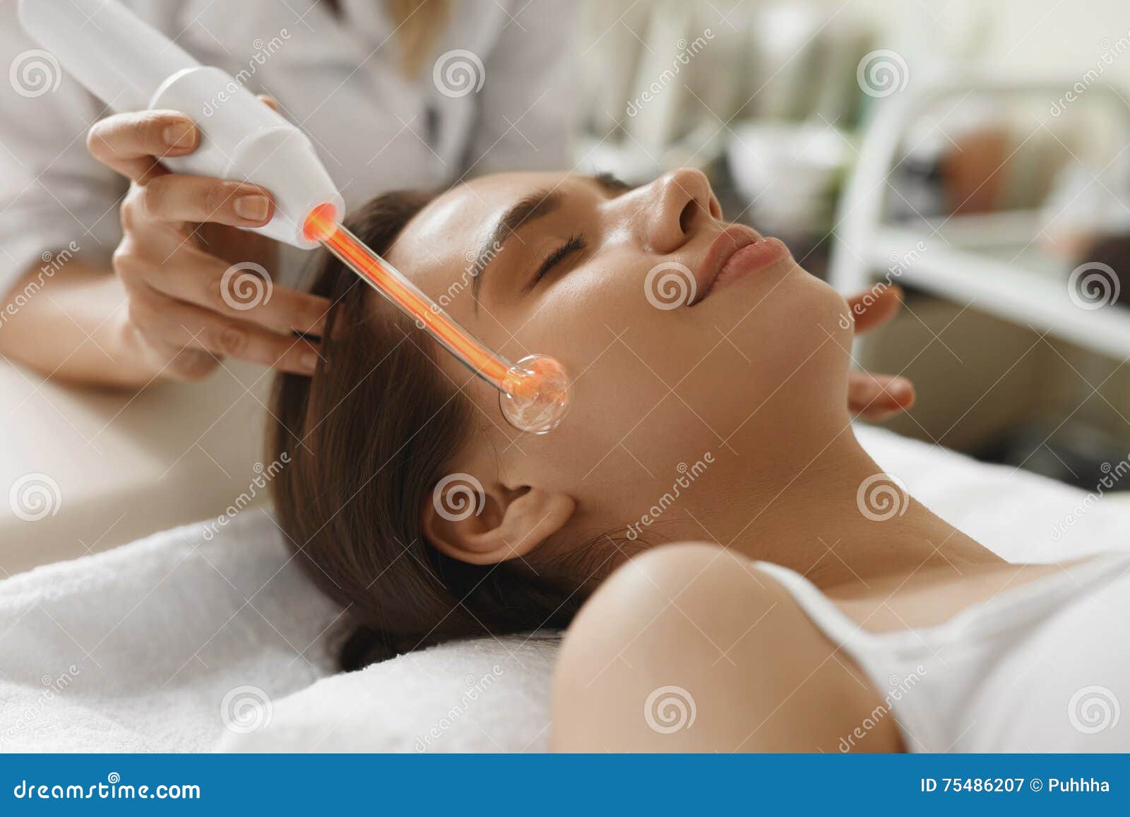 face beauty treatment. woman using darsonval skin care device