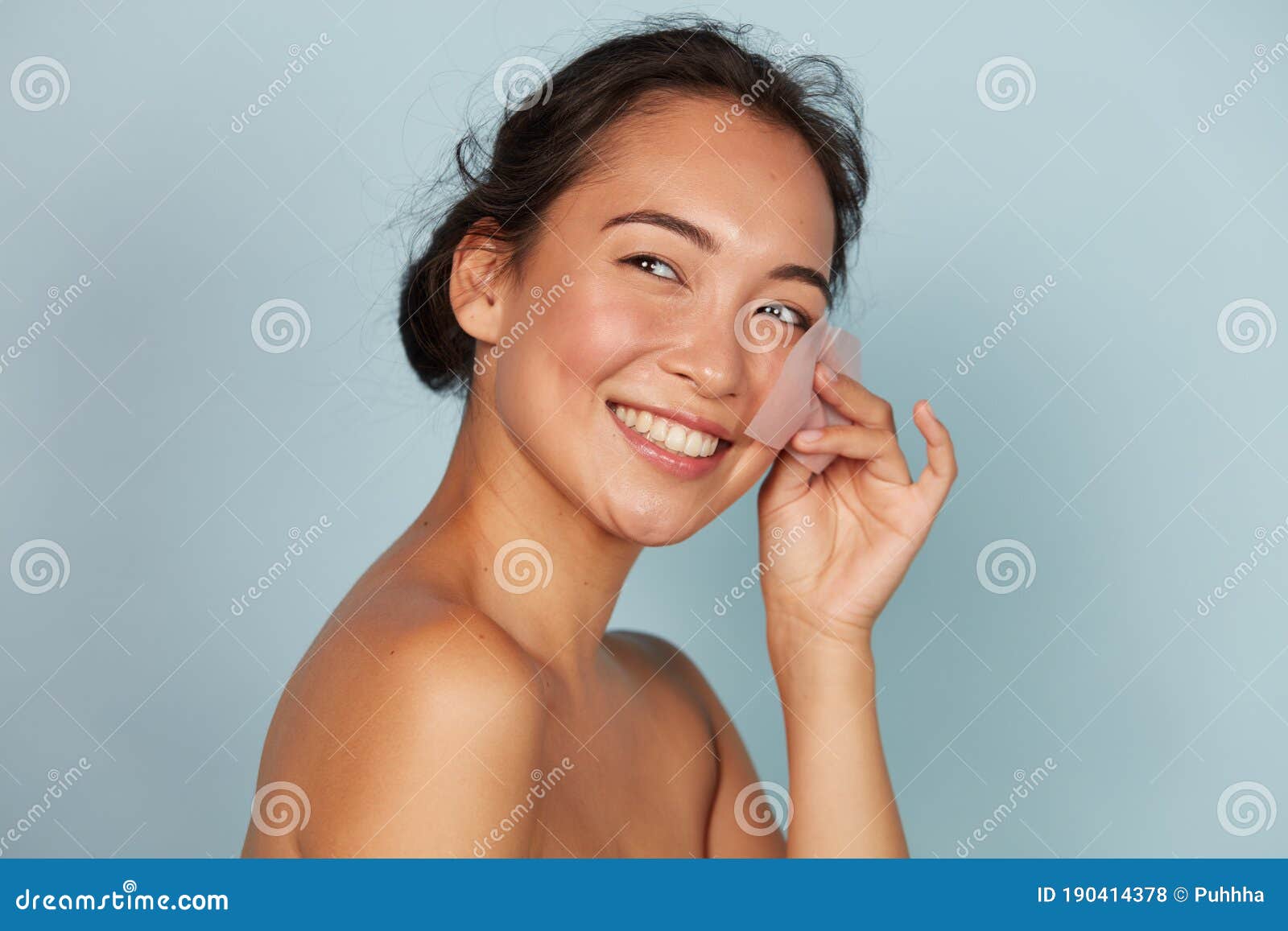 face skin care. smiling woman using oil blotting paper portrait