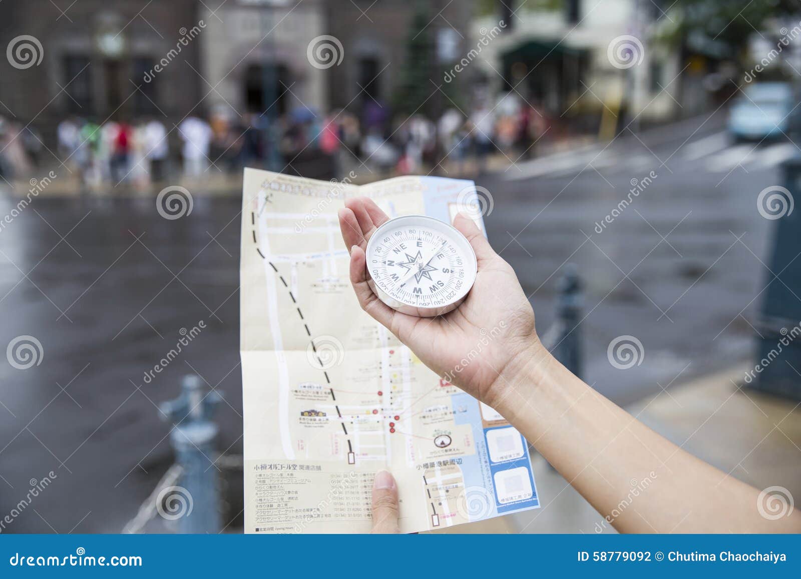 Facendo uso di una bussola e di una mappa per i viaggiatori a Otaru Giappone. Donna che utilizza una bussola e una mappa per i viaggiatori a Otaru Giappone