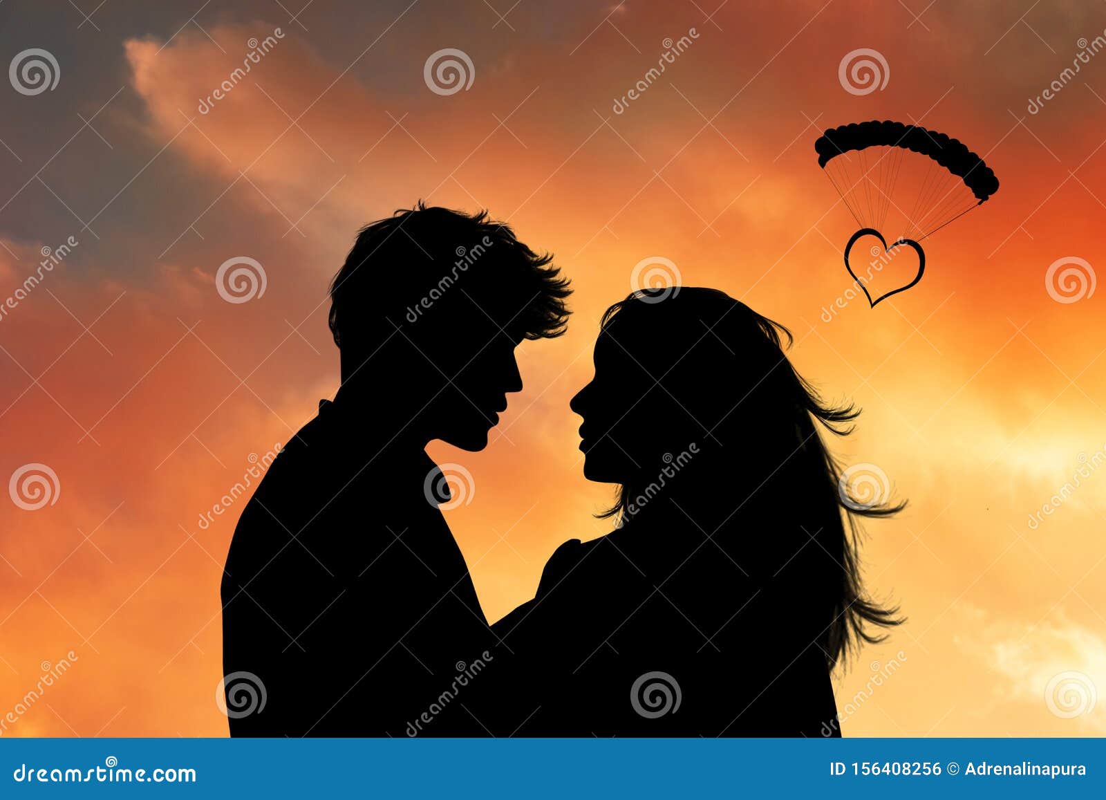 faces of two lovers at sunset with a heart