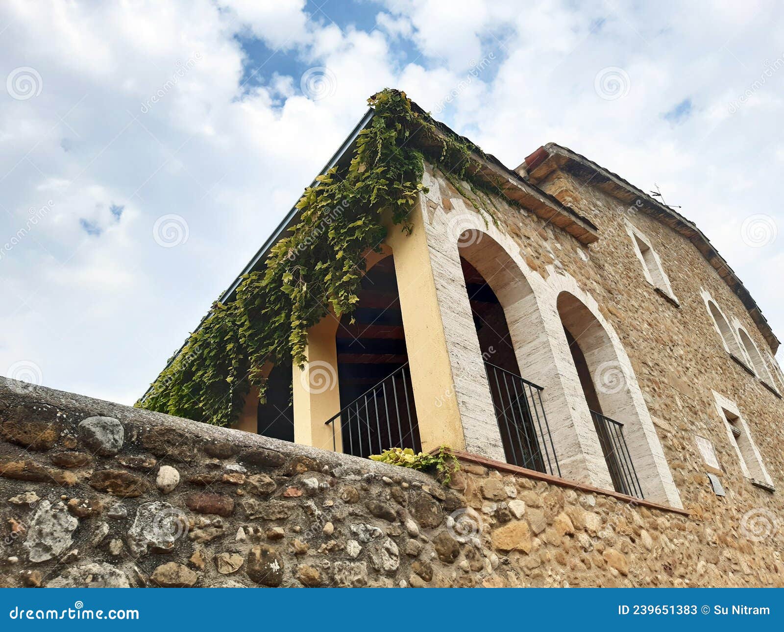 Fachada de casa contemporânea com pedra ferro e madeira + muro de