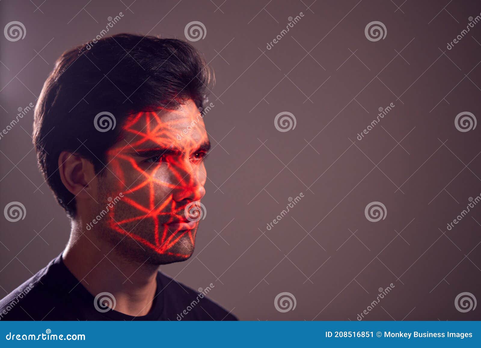 facial recognition technology concept as man has red grid projected onto face in studio