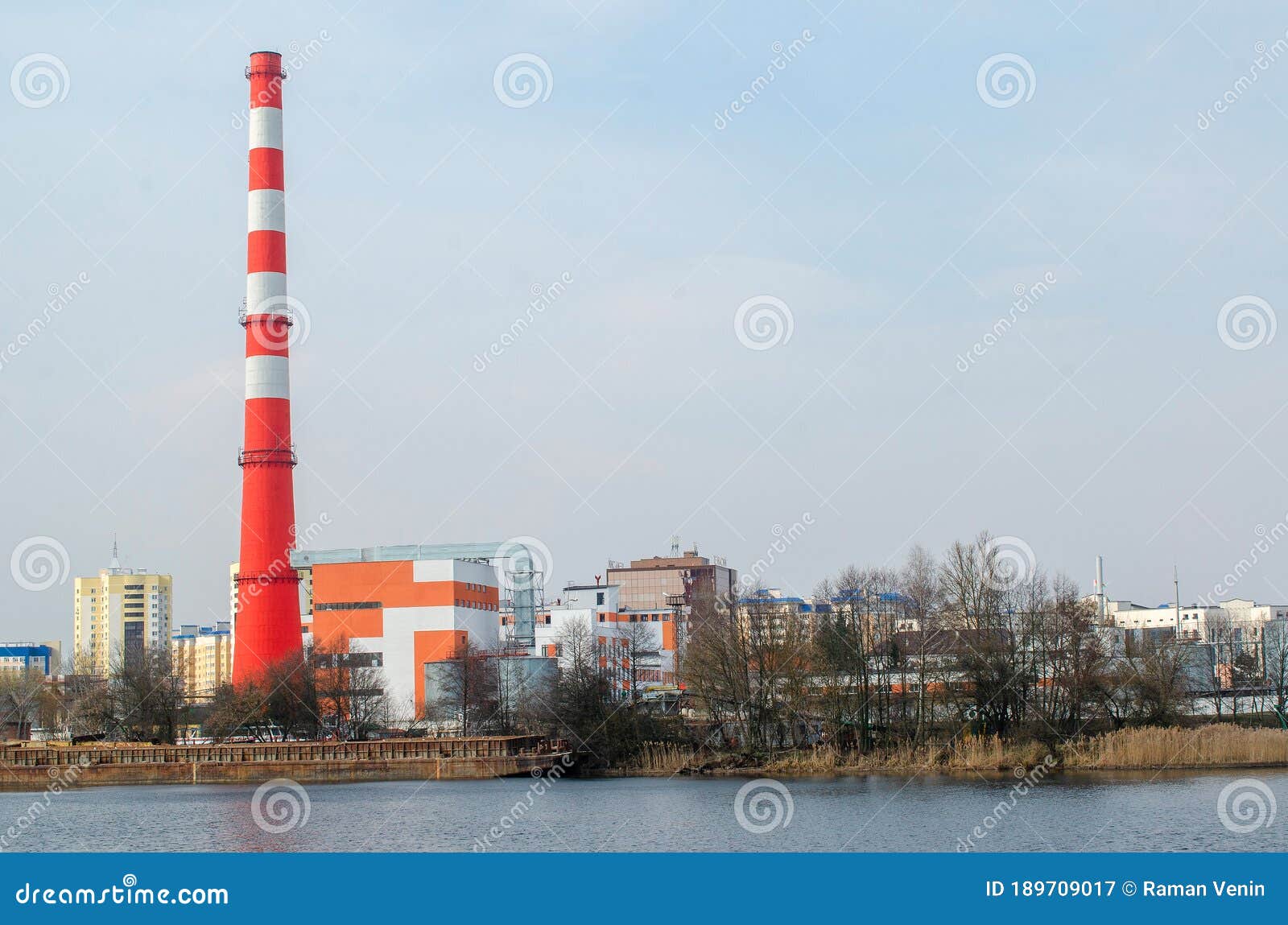 factory pipe for the release of toxic waste on the shore of a reservoir.