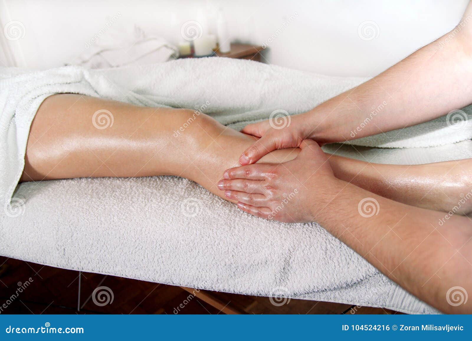 Fahrwerkbein-Massage Der männliche Masseurtherapeut übergibt das Handeln, Druck anwendend knetend auf weiblicher Kalbbeinmassage Berufsmasseuse, die Fuß des Mädchens massiert Frau, die Sportfußmassage im Badekurort-Salon hat