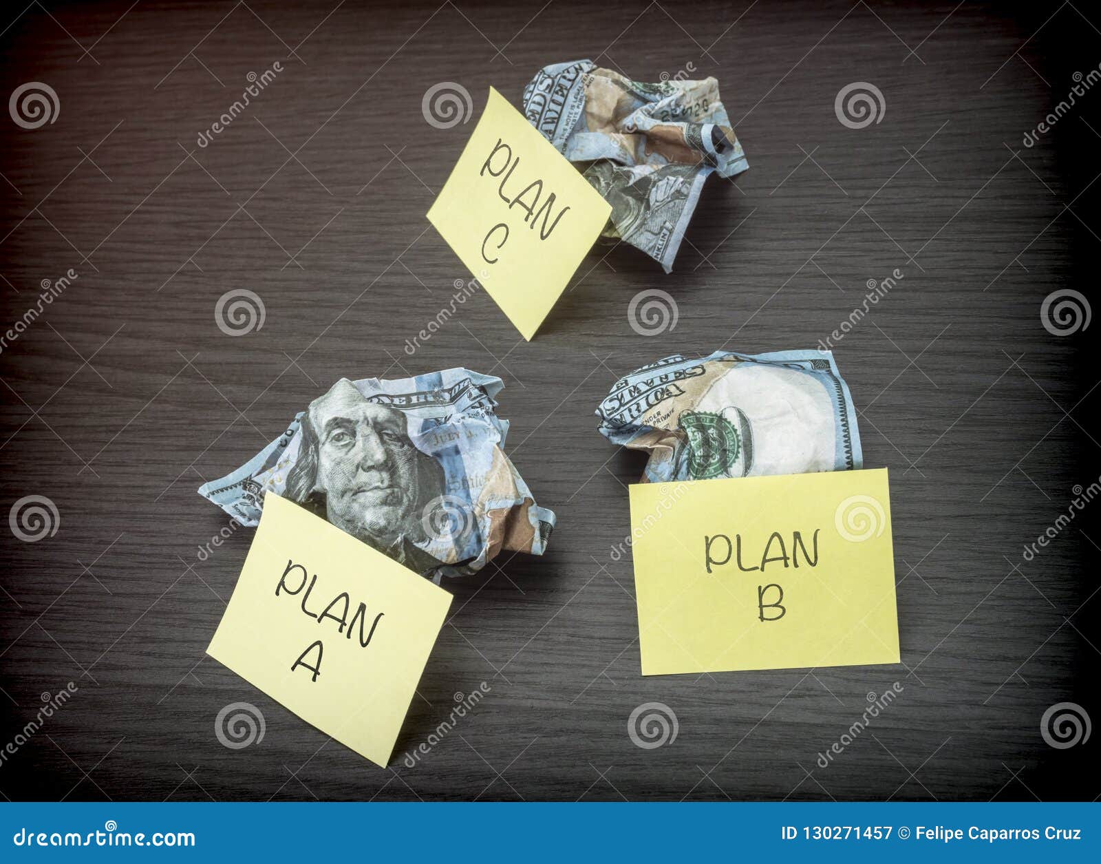 failed business plan a, b and c, minted dollar banknotes on a wooden desk