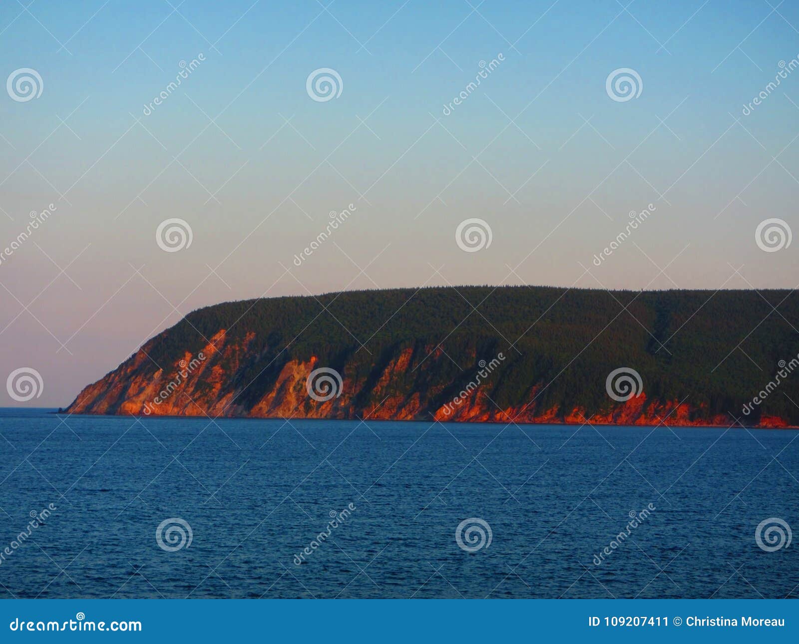 Falaises d'Oceanside à la plage Nova Scotia d'Ingonish de coucher du soleil. Vue des falaises d'oceanside au coucher du soleil Montagnes bretonnes Nova Scotia Canada de cap de plage d'Ingonish Stationnement national de montagnes bretonnes de cap Canada 150