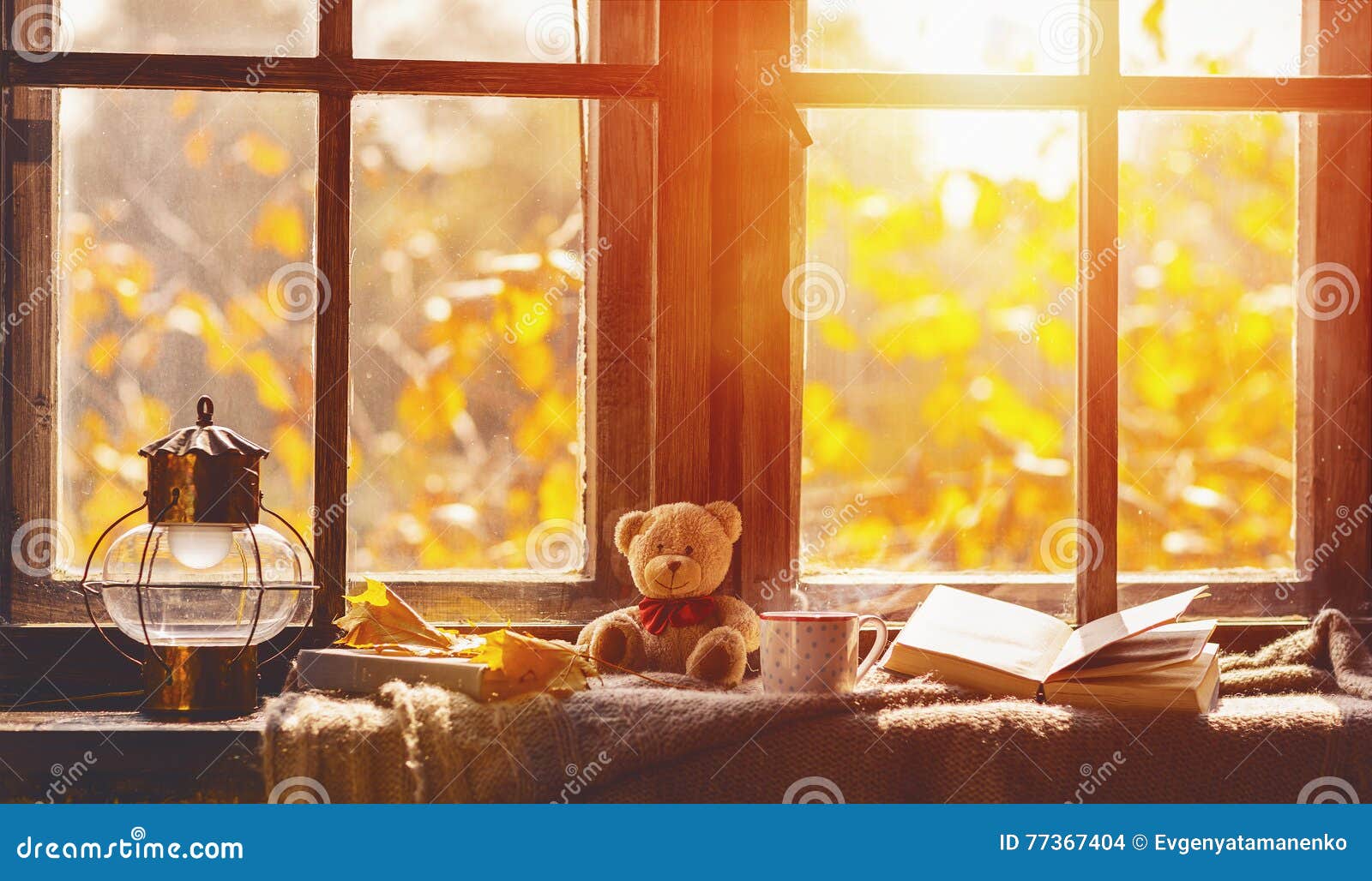 fall. cozy window with autumn leaves, book, mug of tea
