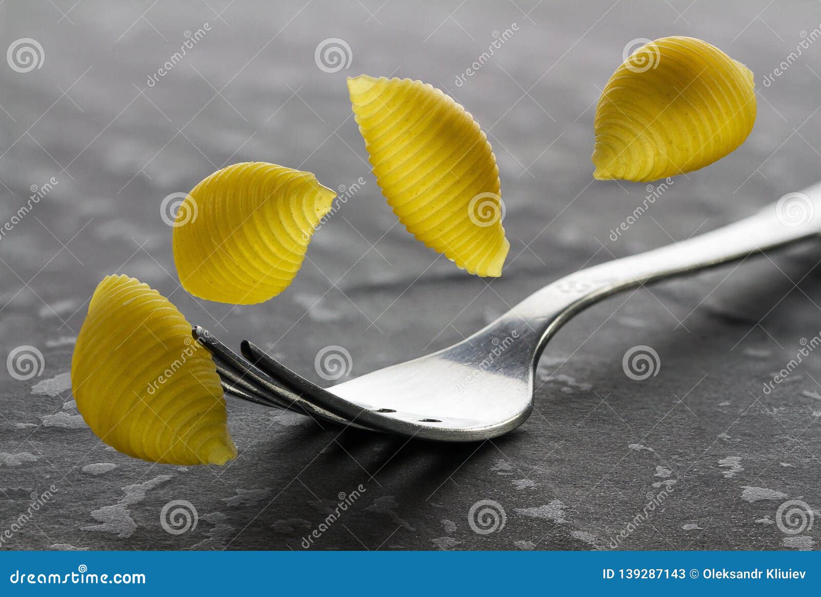 Falling Pasta, Macaroni and Fork Closeup on Textural Stone Background